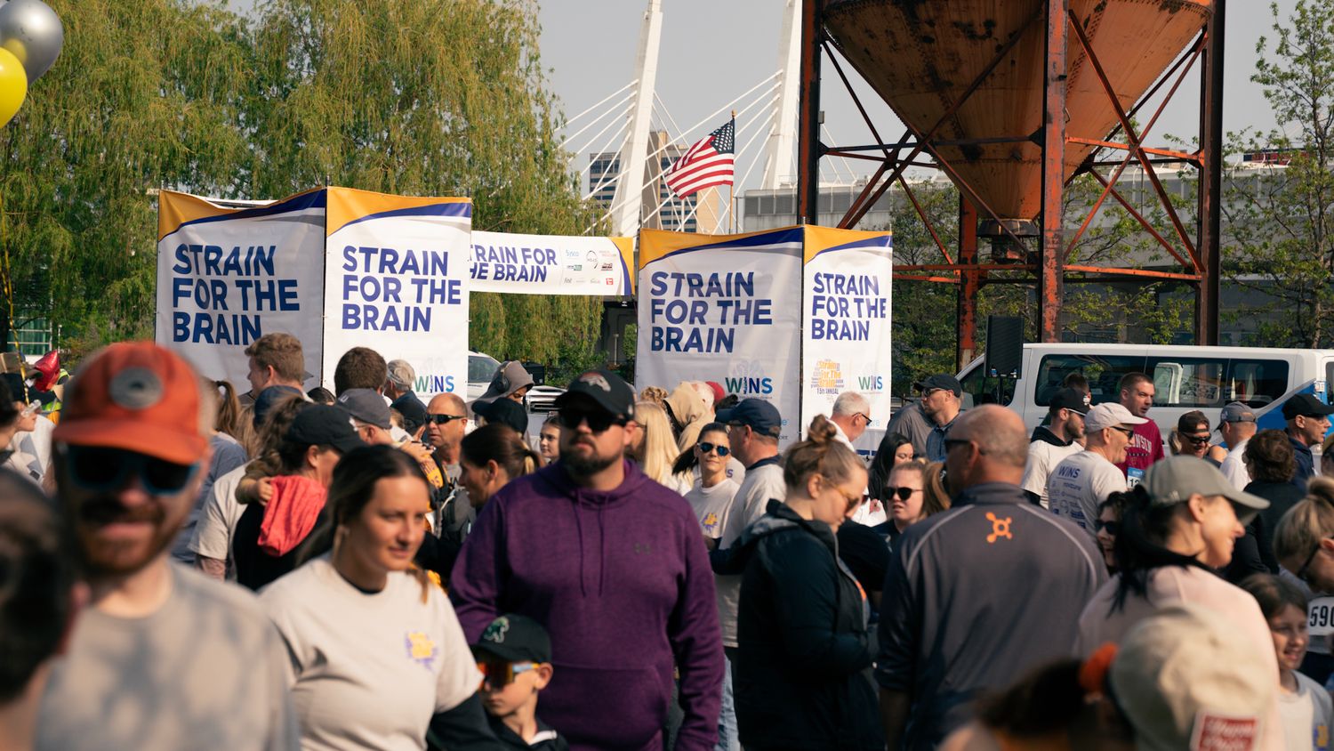 Protest crowd holding signs about trains during daytime rally.