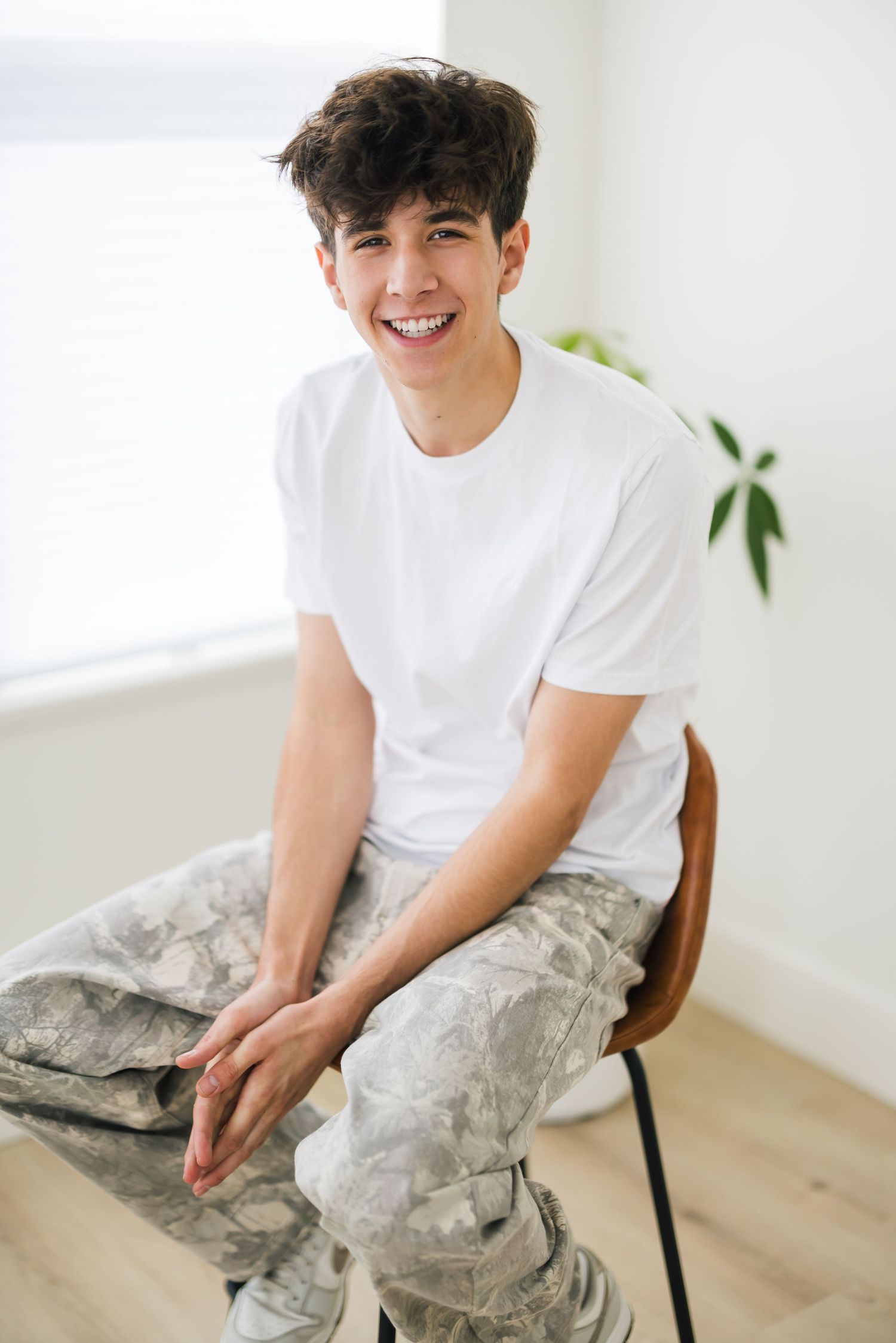 Senior boy photographed in Utah studio with bold lighting and relaxed pose