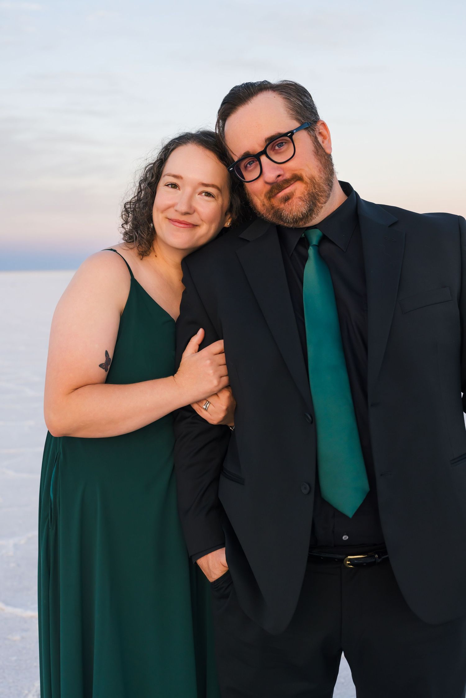 Couple in formal wear sharing intimate moments against a white salt flats wendover backdrop at sunset. family portraits at the salt flats