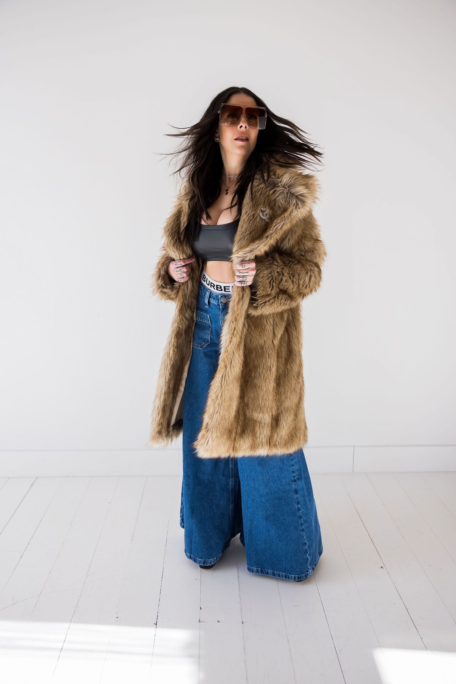 Fashion photo featuring denim jumpsuit and brown faux fur coat against white background.