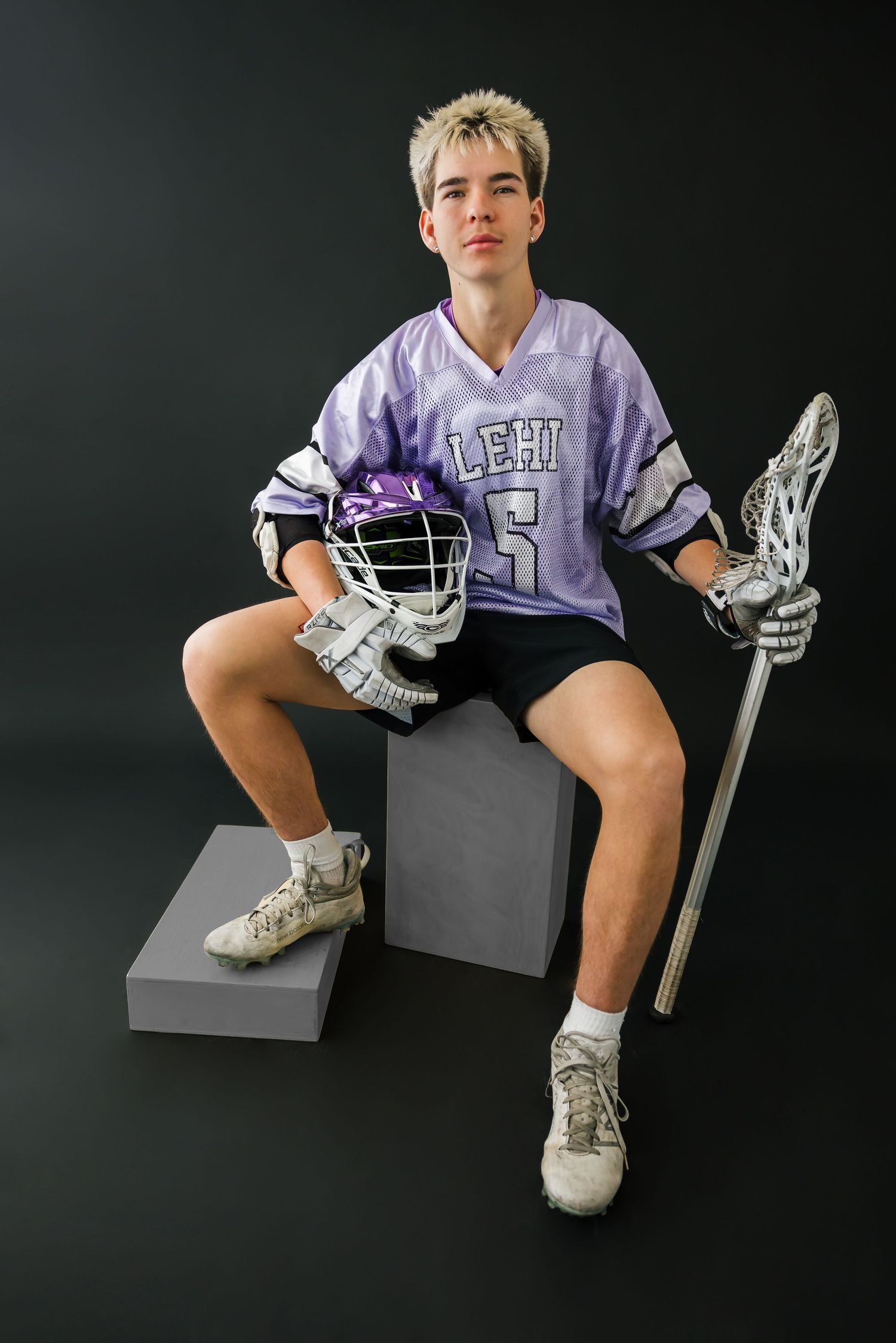 Studio senior photo of lacrosse athlete with dramatic lighting taken in studio in salt lake city