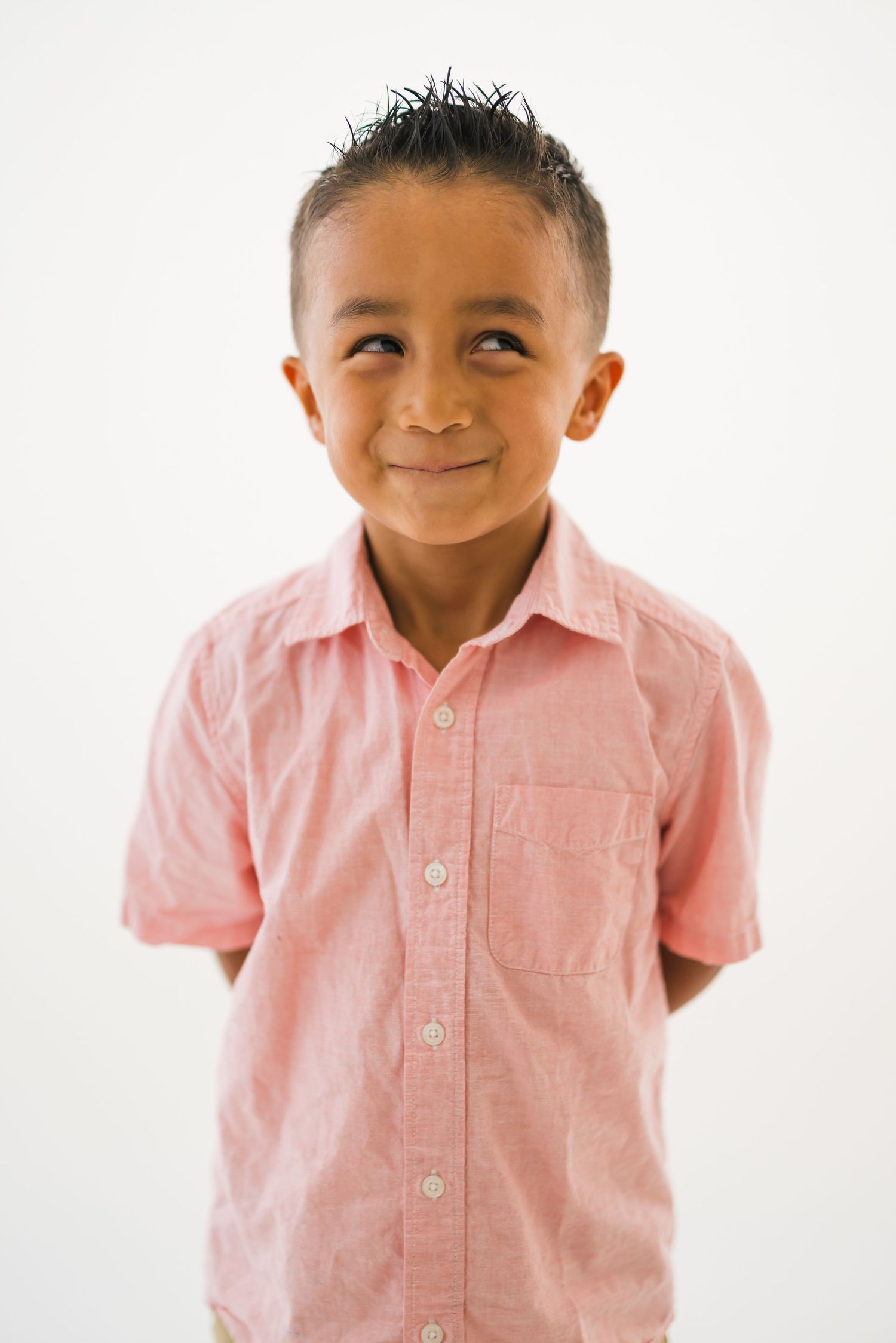 Three sequential photos of a young child in a pink button-up shirt showing different playful expressions.