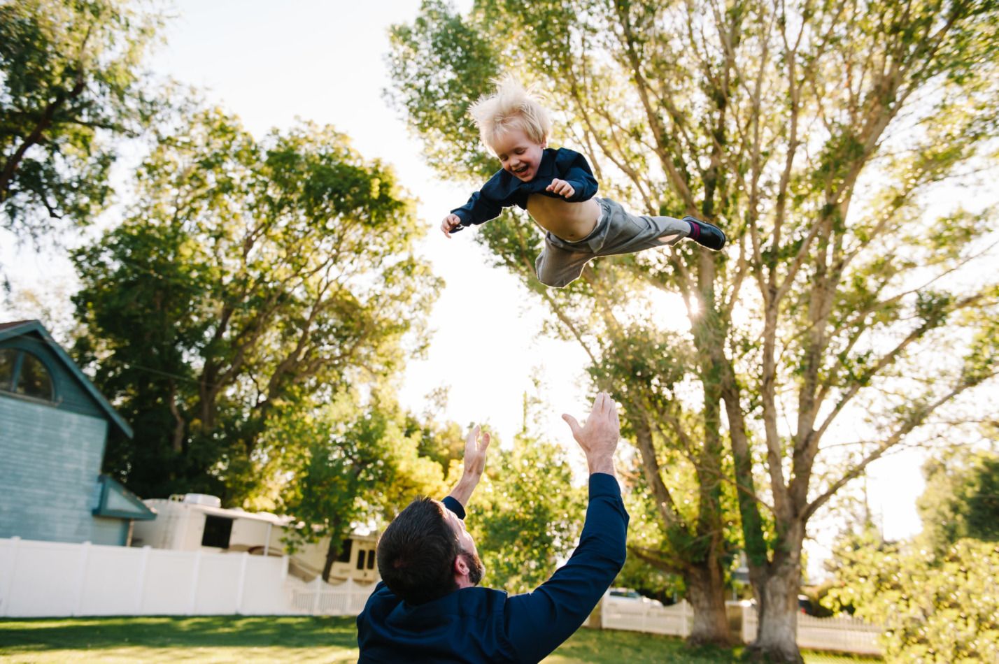 Joyful moment captured as child is tossed in the air outdoors.