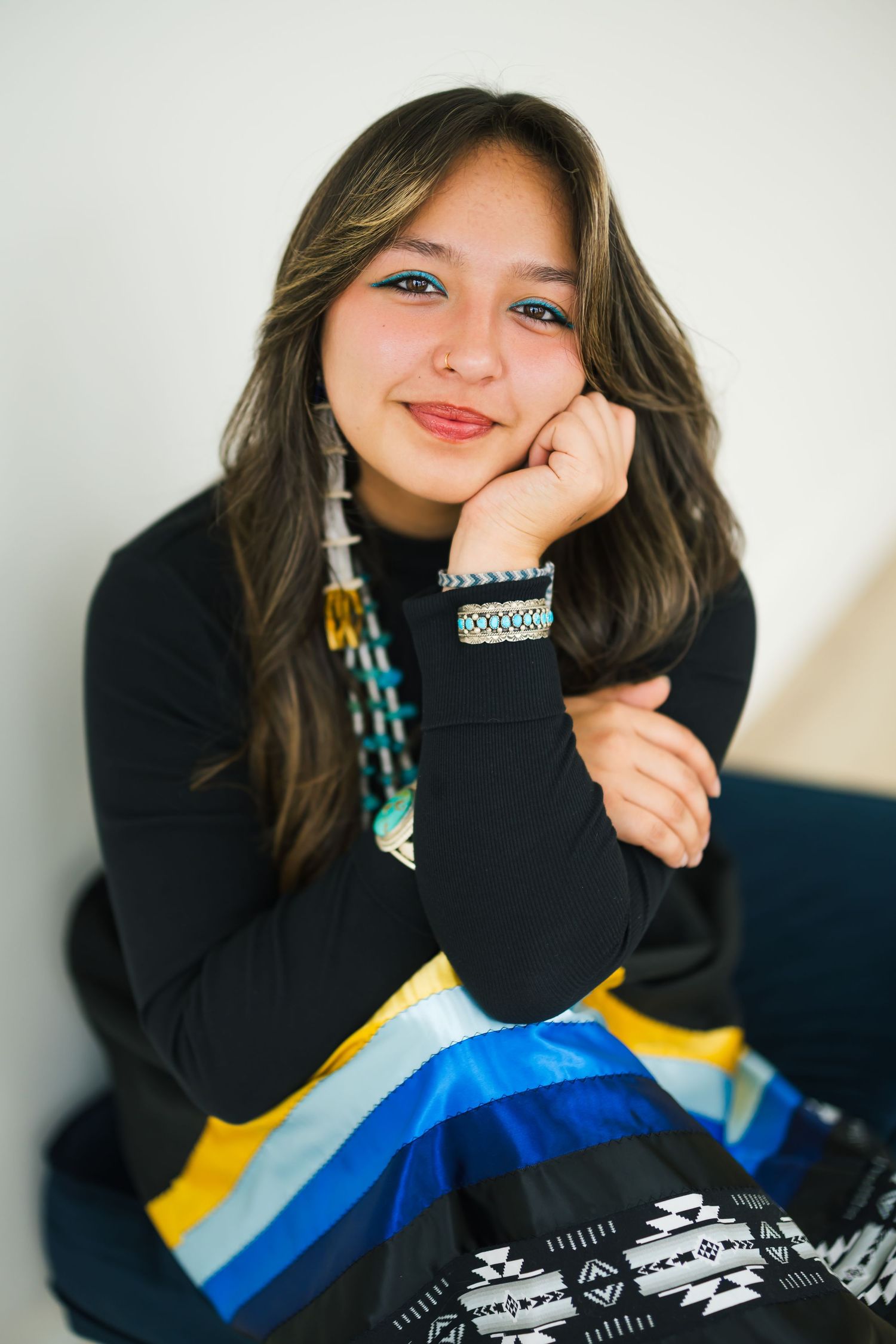 Senior girl studio session with relaxed pose and minimal background