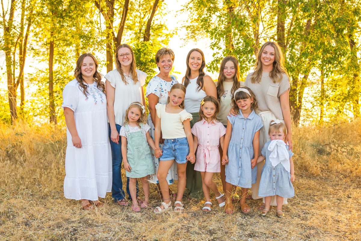 Group photo of multigenerational family wearing coordinated light summer outfits.