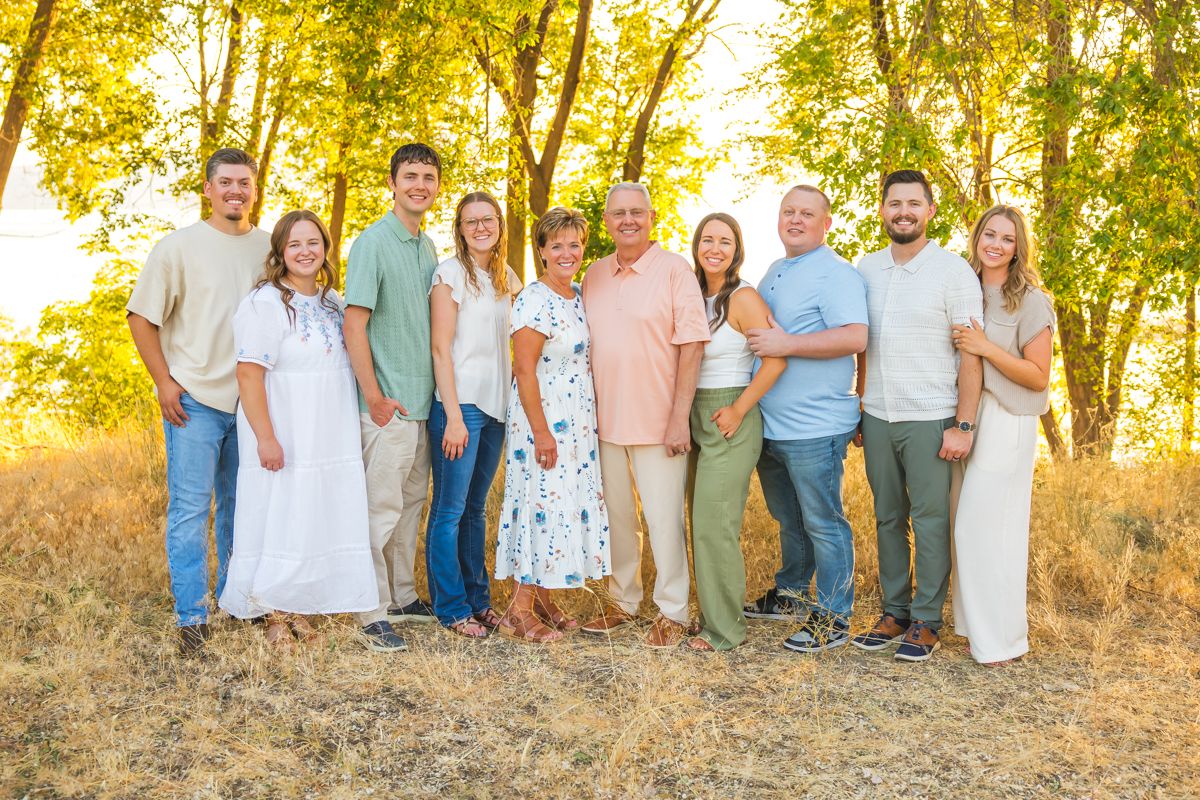 Casual extended family photo session outdoors with natural golden lighting.