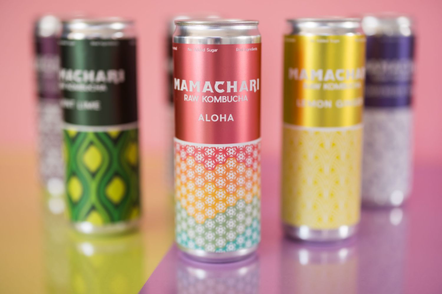 Colorful array of craft beer cans with vibrant designs and patterns displayed in a row on a pink background.