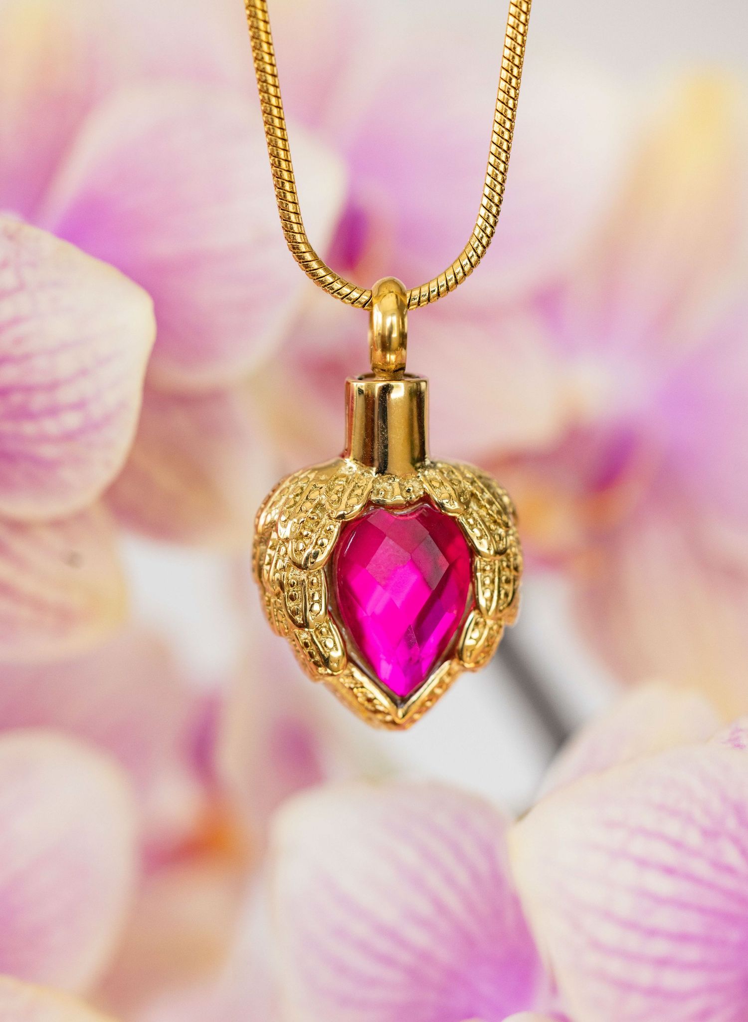 Gold heart-shaped pendant necklace with pink gemstone shown in sequence against soft floral background.