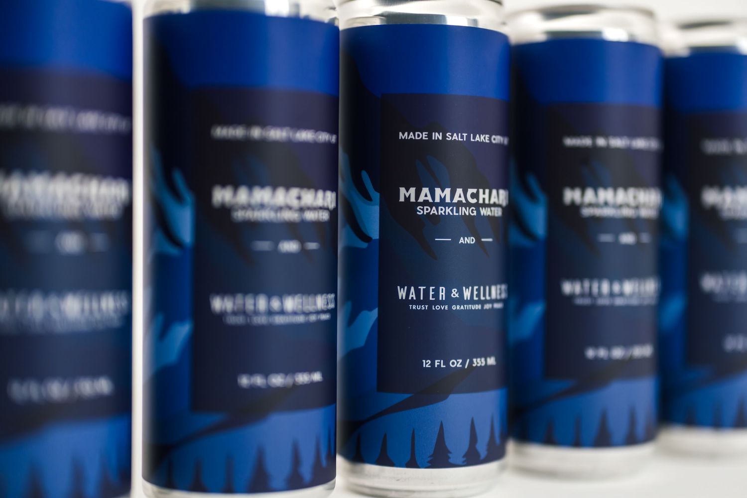 Blue cylindrical containers with white text arranged in rows on a shelf display a collection of products.