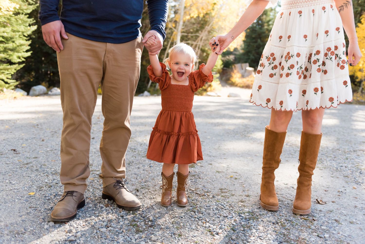 Lower body shot of three people standing together on a gravel path.