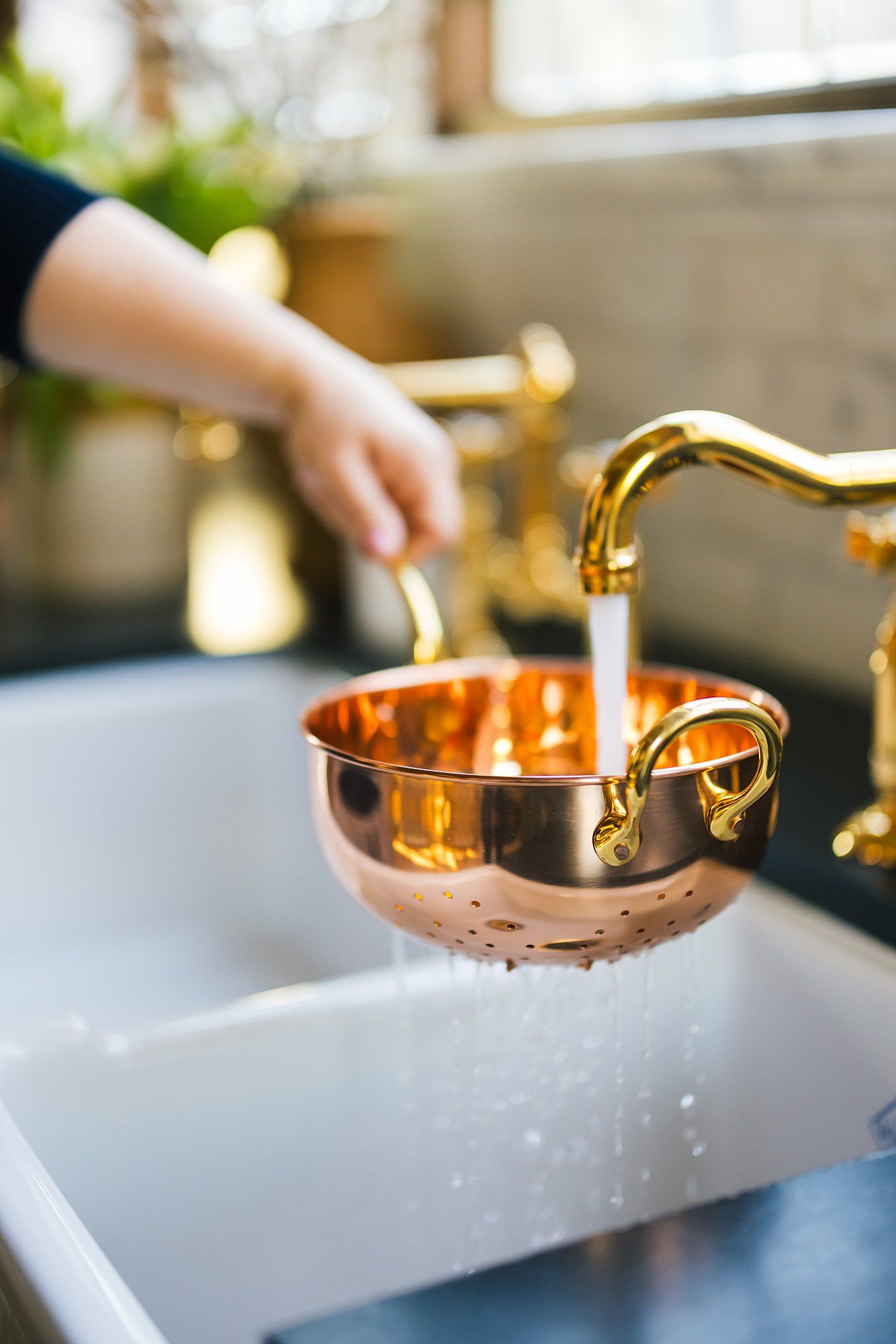 Gold and copper measuring cups being used on white marble counter surface.