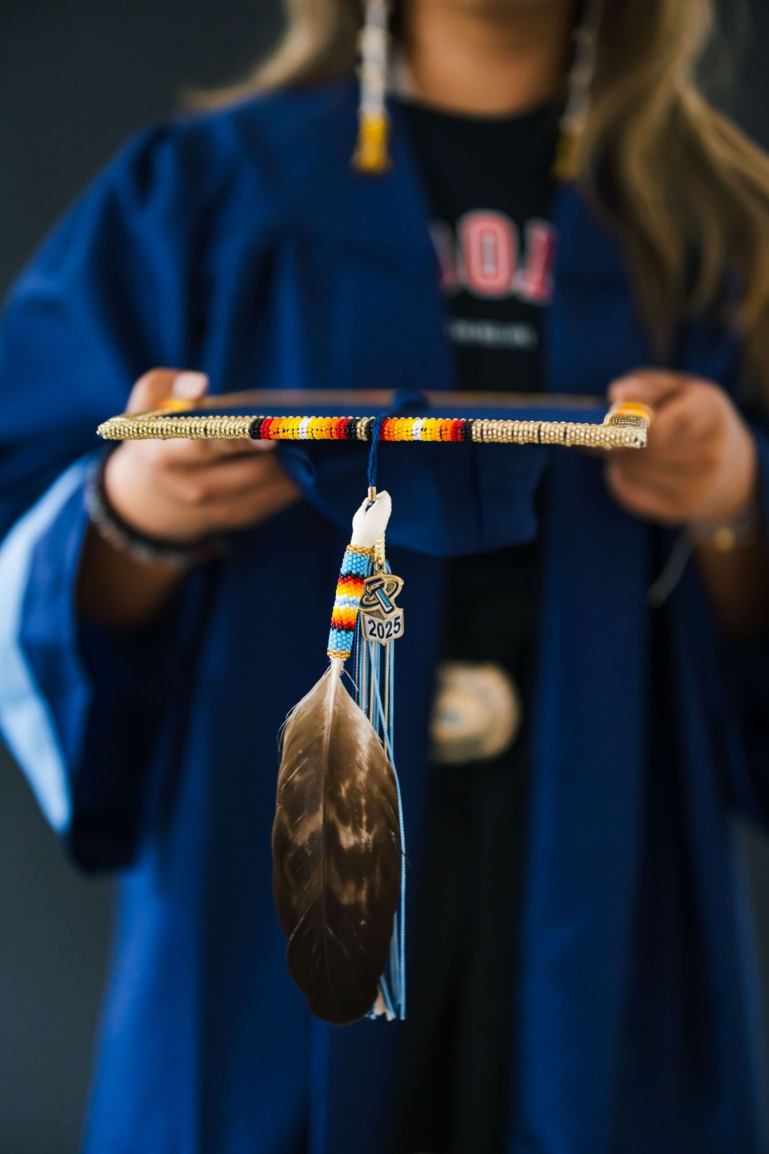 Close-up sequence of tassel ornaments on graduation caps against blue backgrounds.
