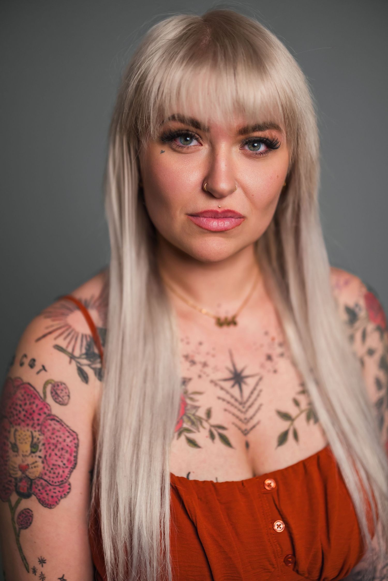 A series of close-up portraits showing platinum blonde hair and visible tattoos against a gray studio background.