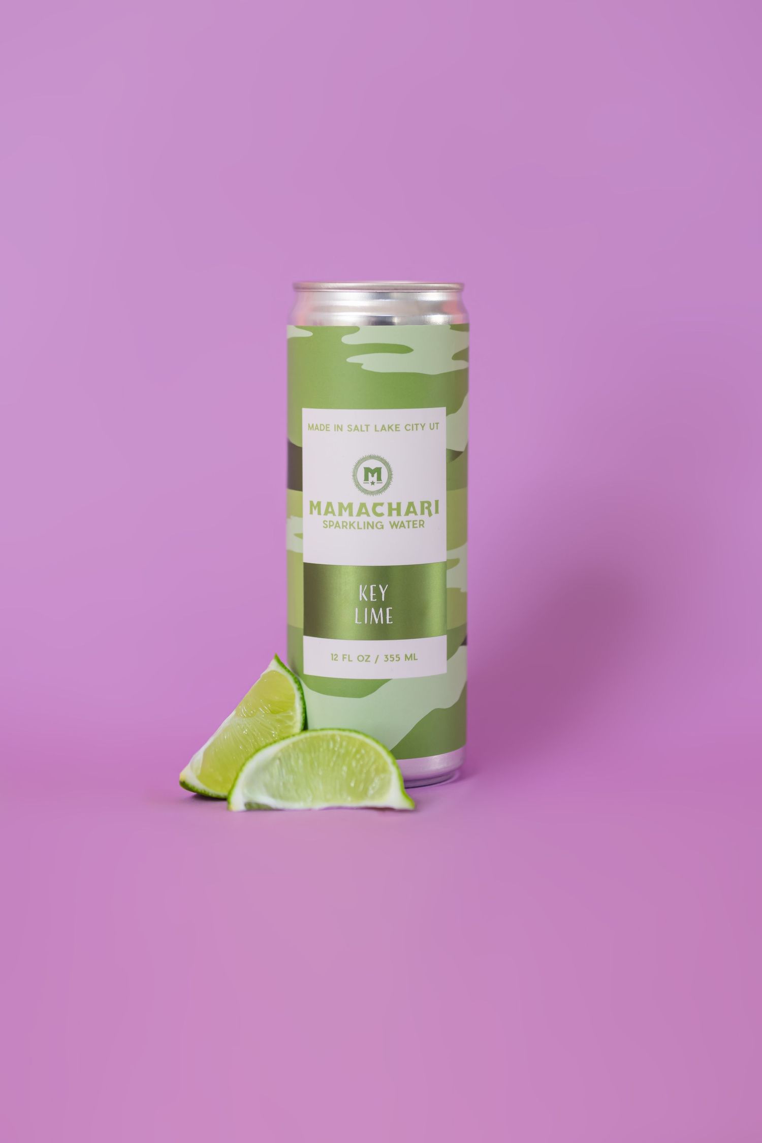 Green tea canister with lime slices on purple background showcasing Mamachari brand packaging.