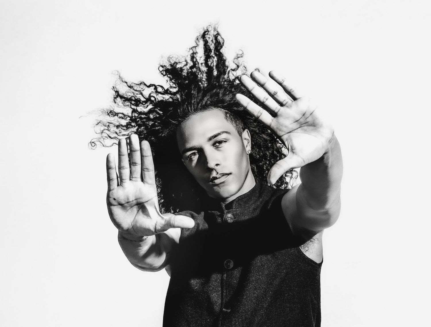 Dynamic black and white portrait series with dramatic hand gestures against white backdrop.