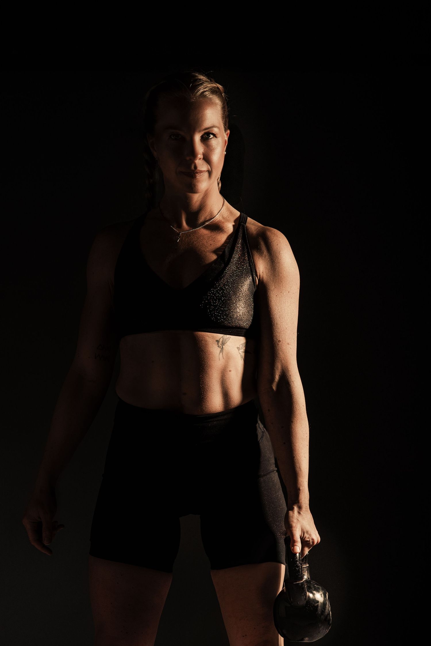 Athletic portrait series in dark lighting showing strength and movement.
