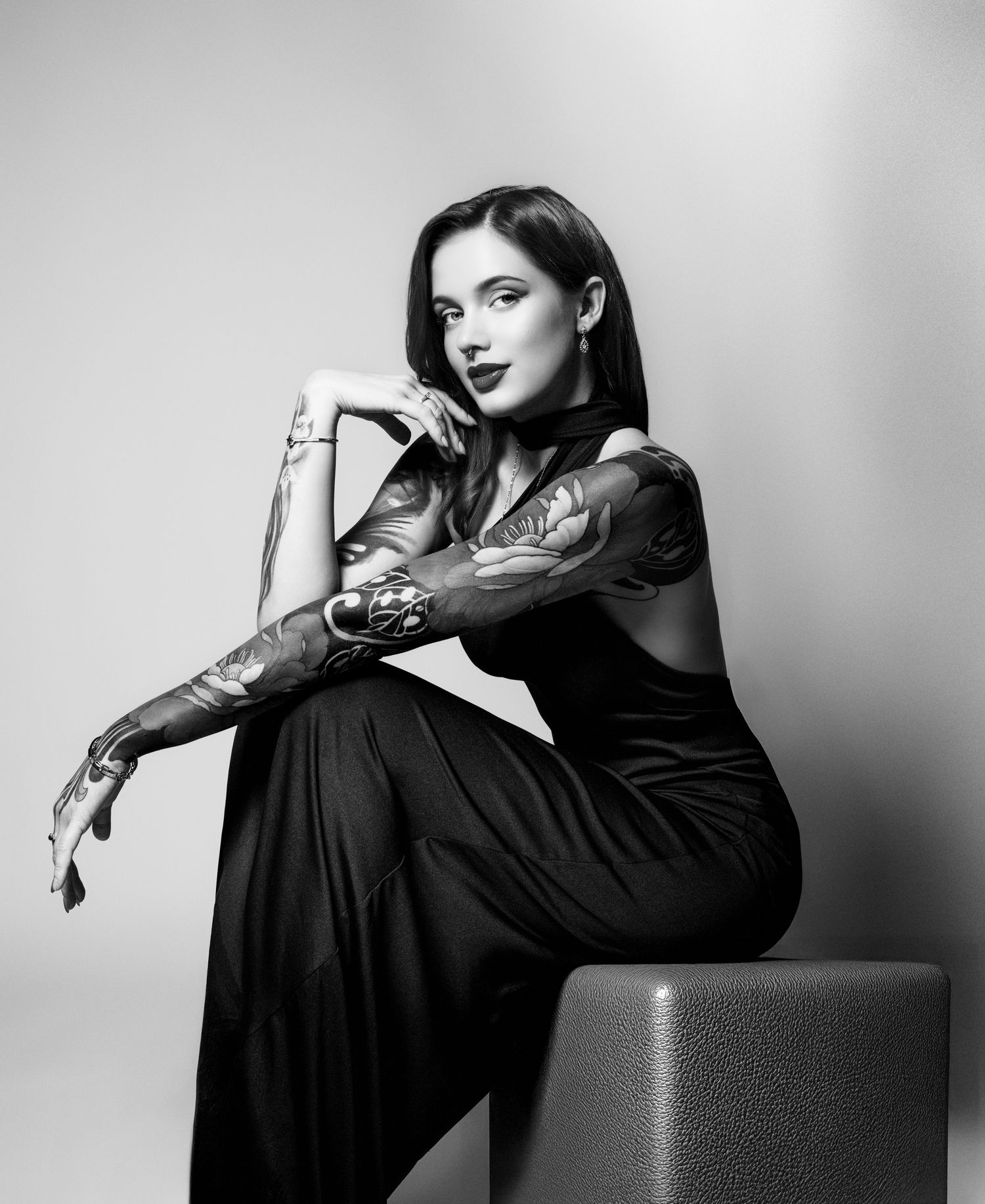 Black and white portrait series featuring dramatic poses on a dark cube seat.