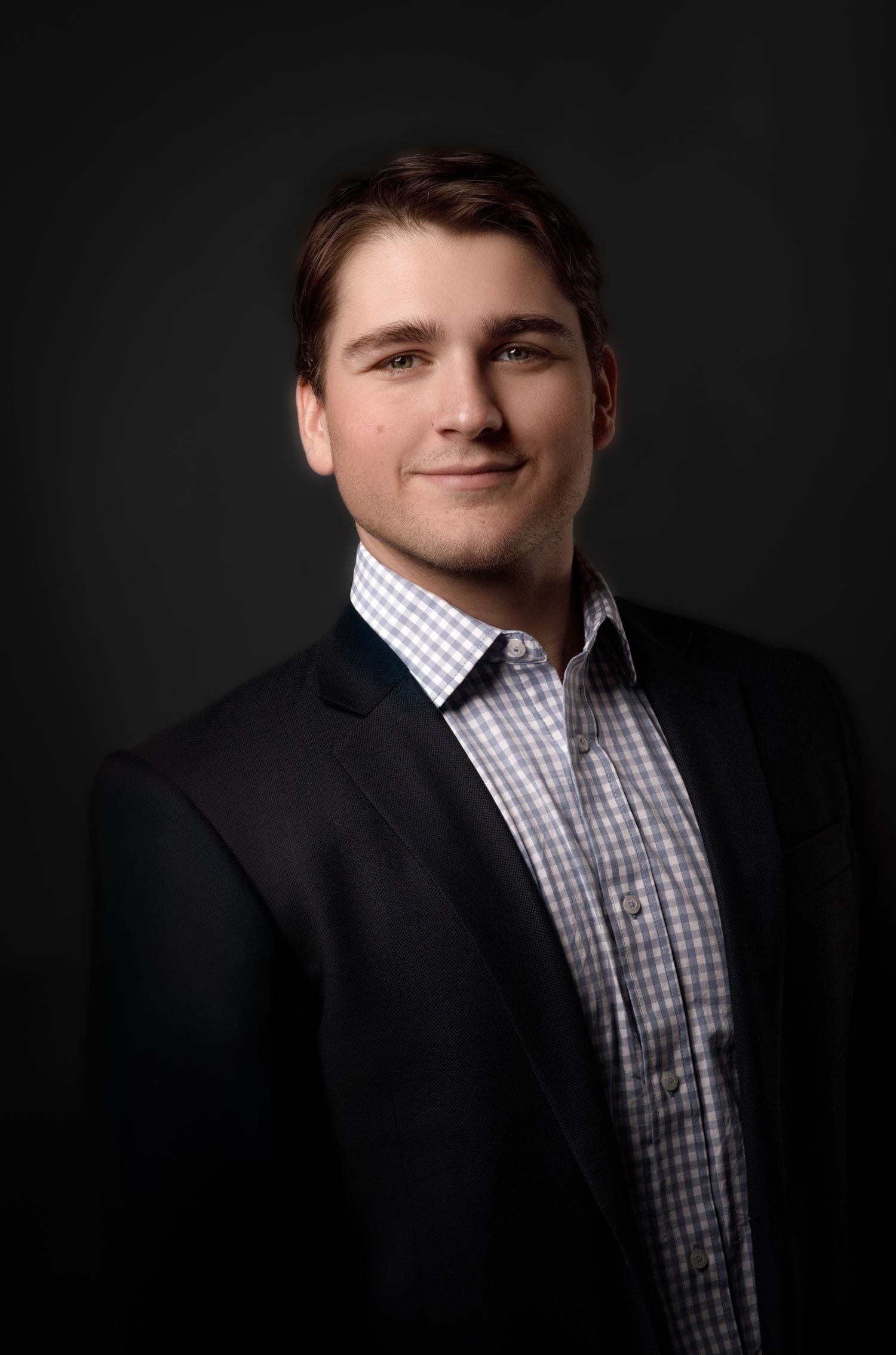 Professional headshot series against dark background showing different angles and expressions.