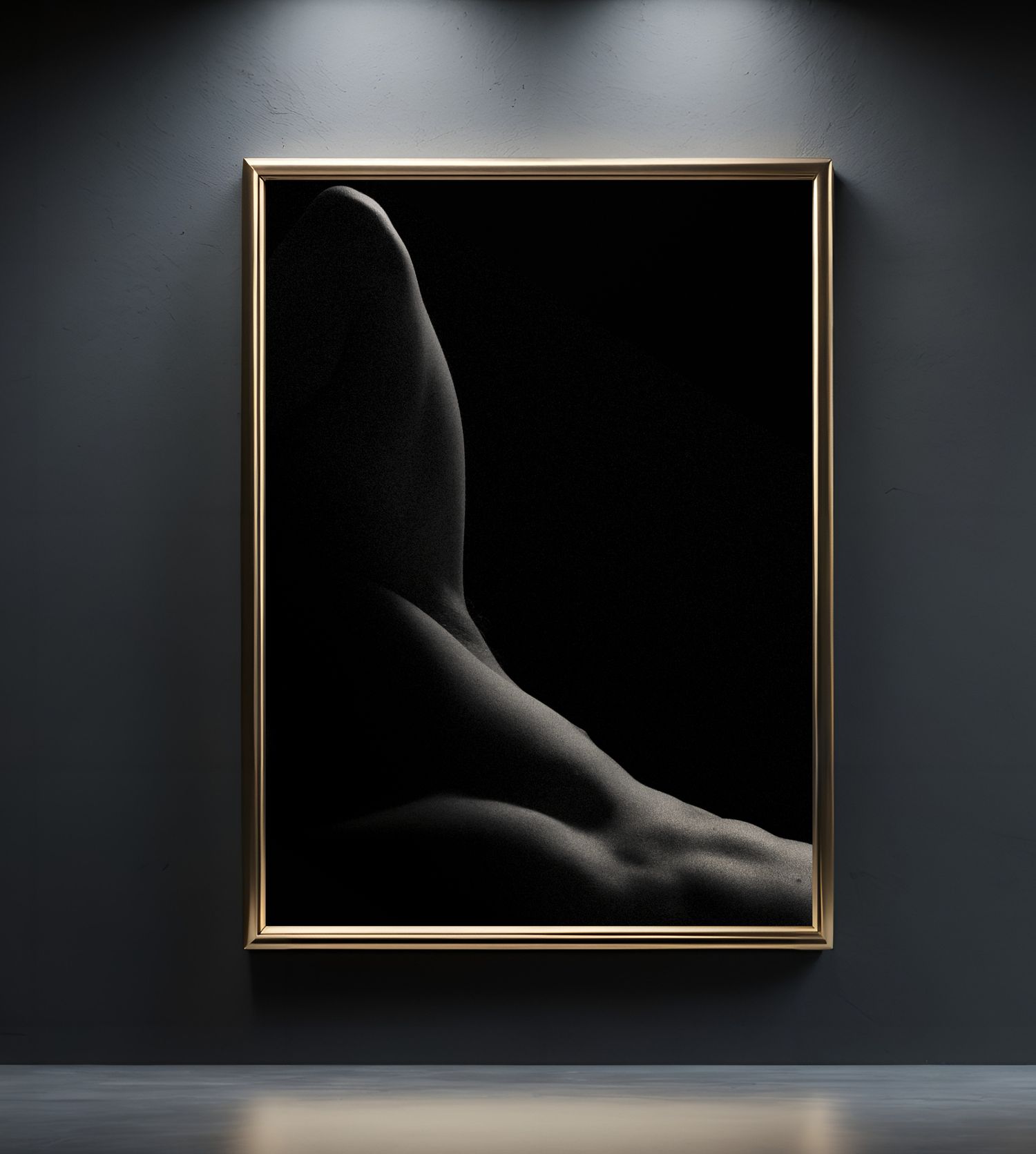 Dramatic black and white fine art nude photograph in a gold frame, displayed on a dark gray gallery wall.