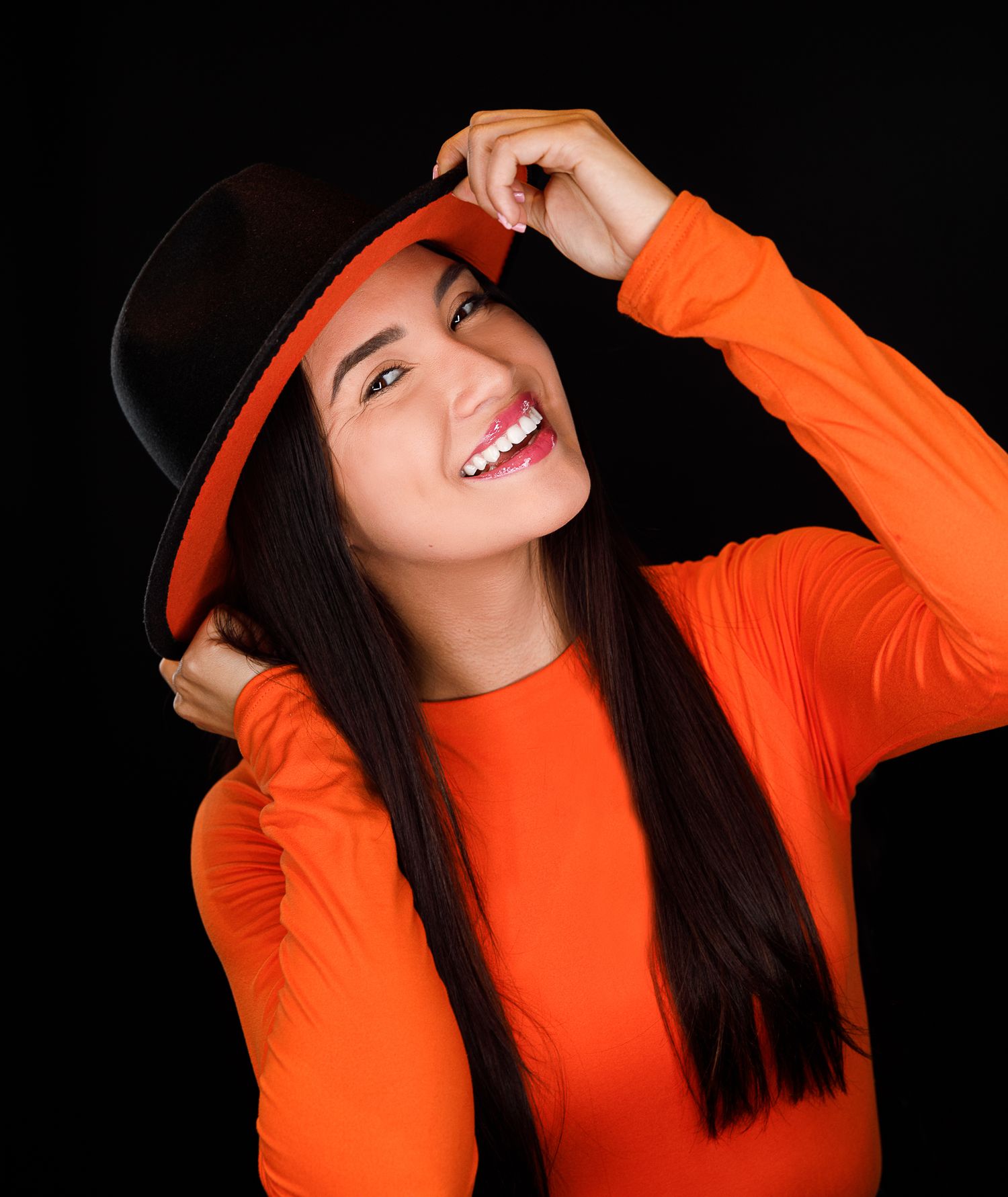 Energetic portrait sequence showing playful poses in orange outfit with black hat.