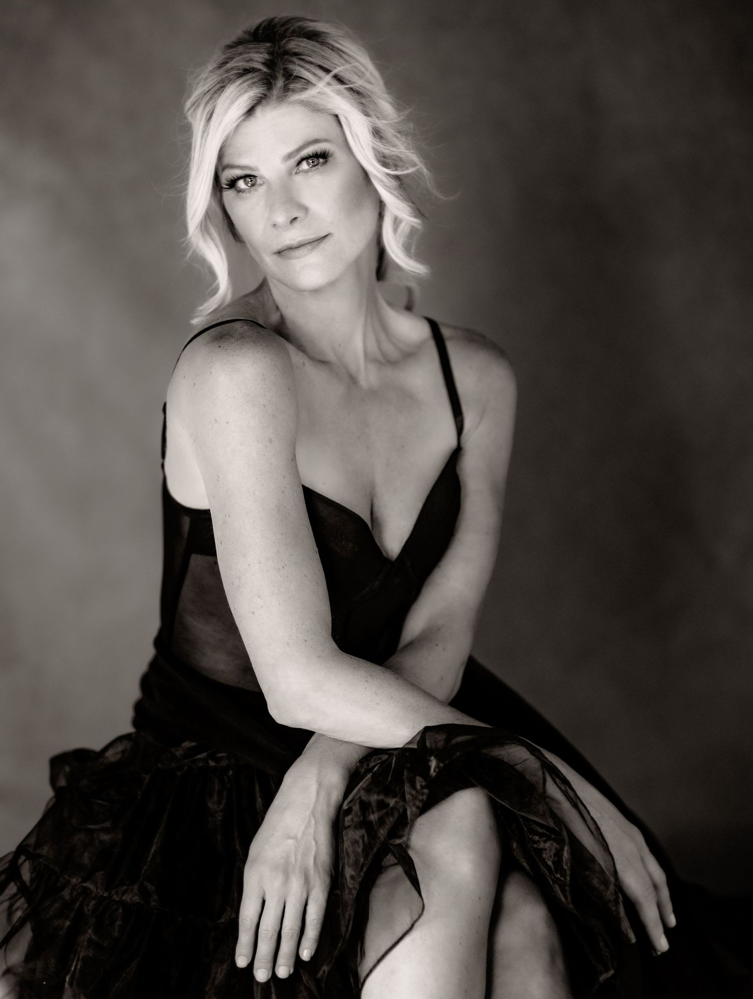 Black and white portrait series featuring dramatic poses in an elegant black dress.