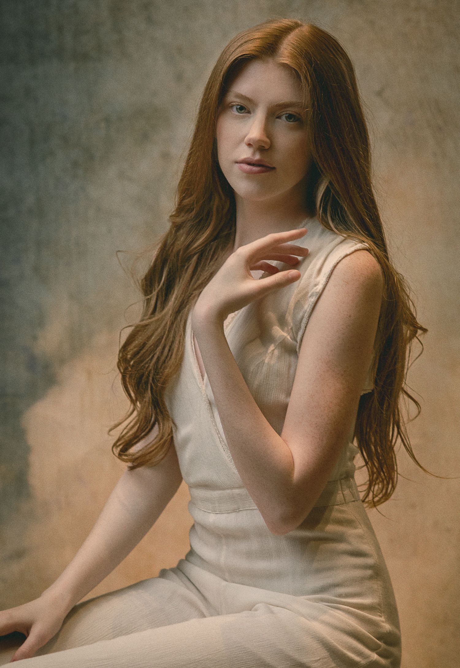 Artistic portrait series in warm tones showing graceful poses in a white sleeveless dress against a textured backdrop.