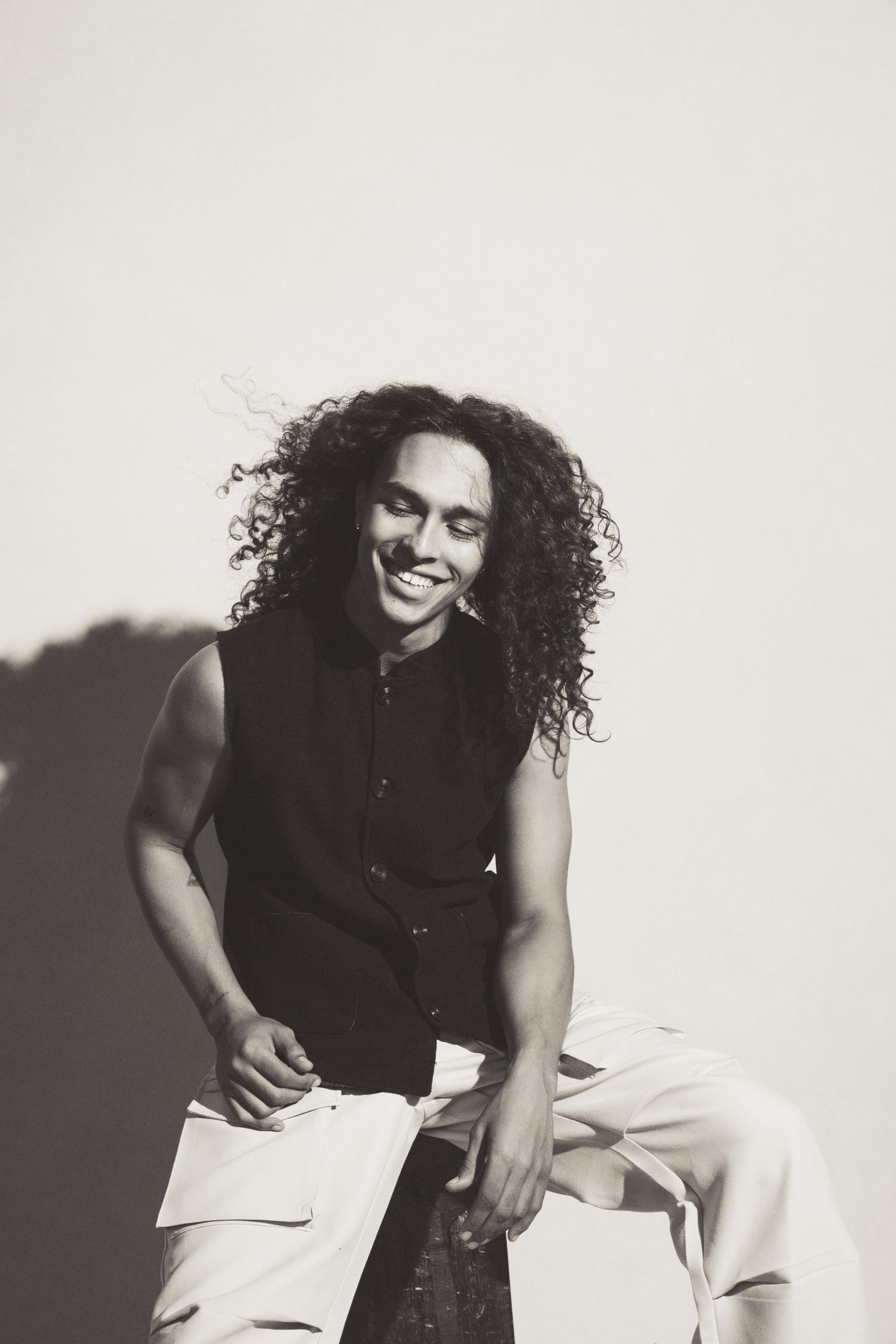 Black and white studio portraits capturing dynamic poses in black top and white pants.