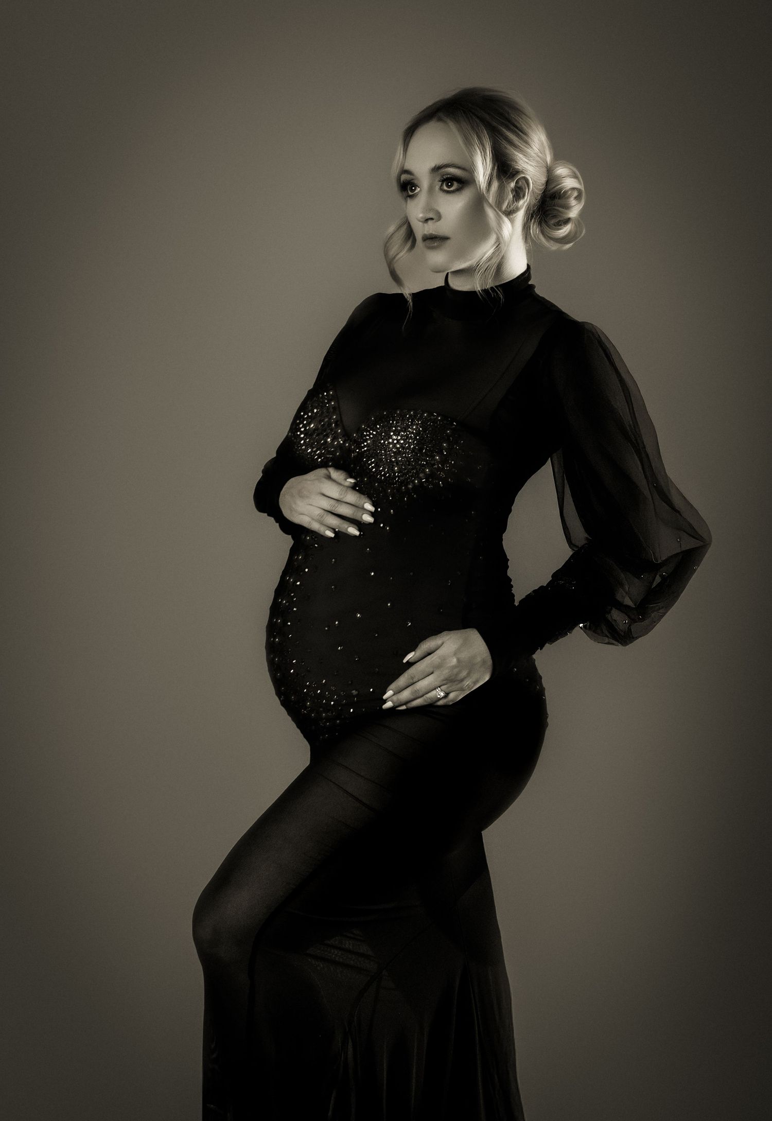 Black and white maternity portraits in a sparkly black dress showing elegant pregnancy silhouette.