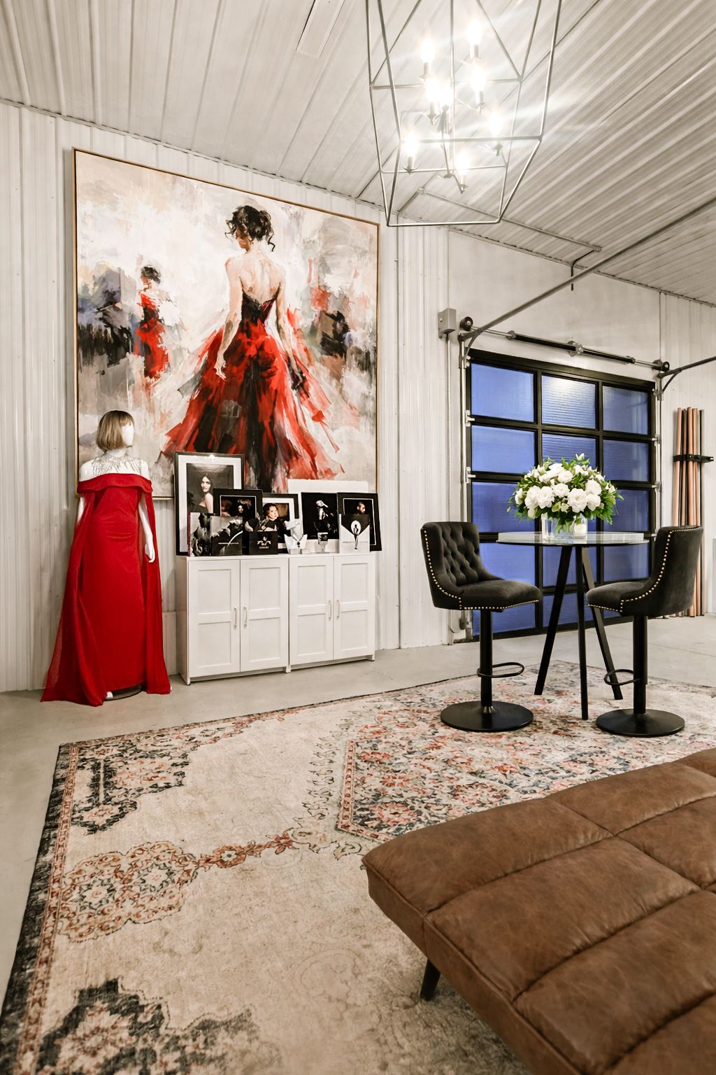 Modern white interior space with red accent decor and chandelier lighting.