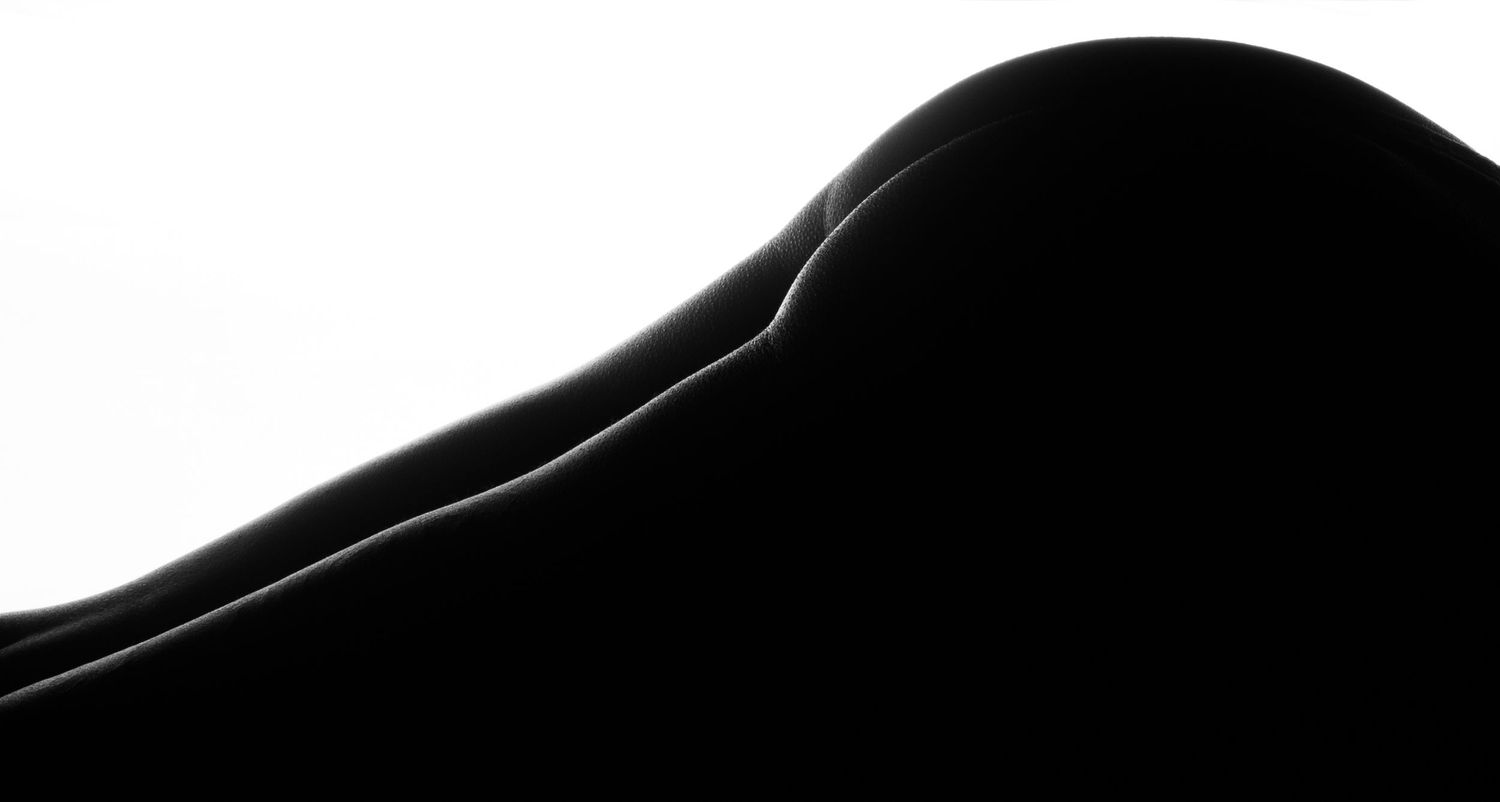 Abstract black and white silhouette photography showcasing smooth curves and contrast in fine art nude bodyscape.