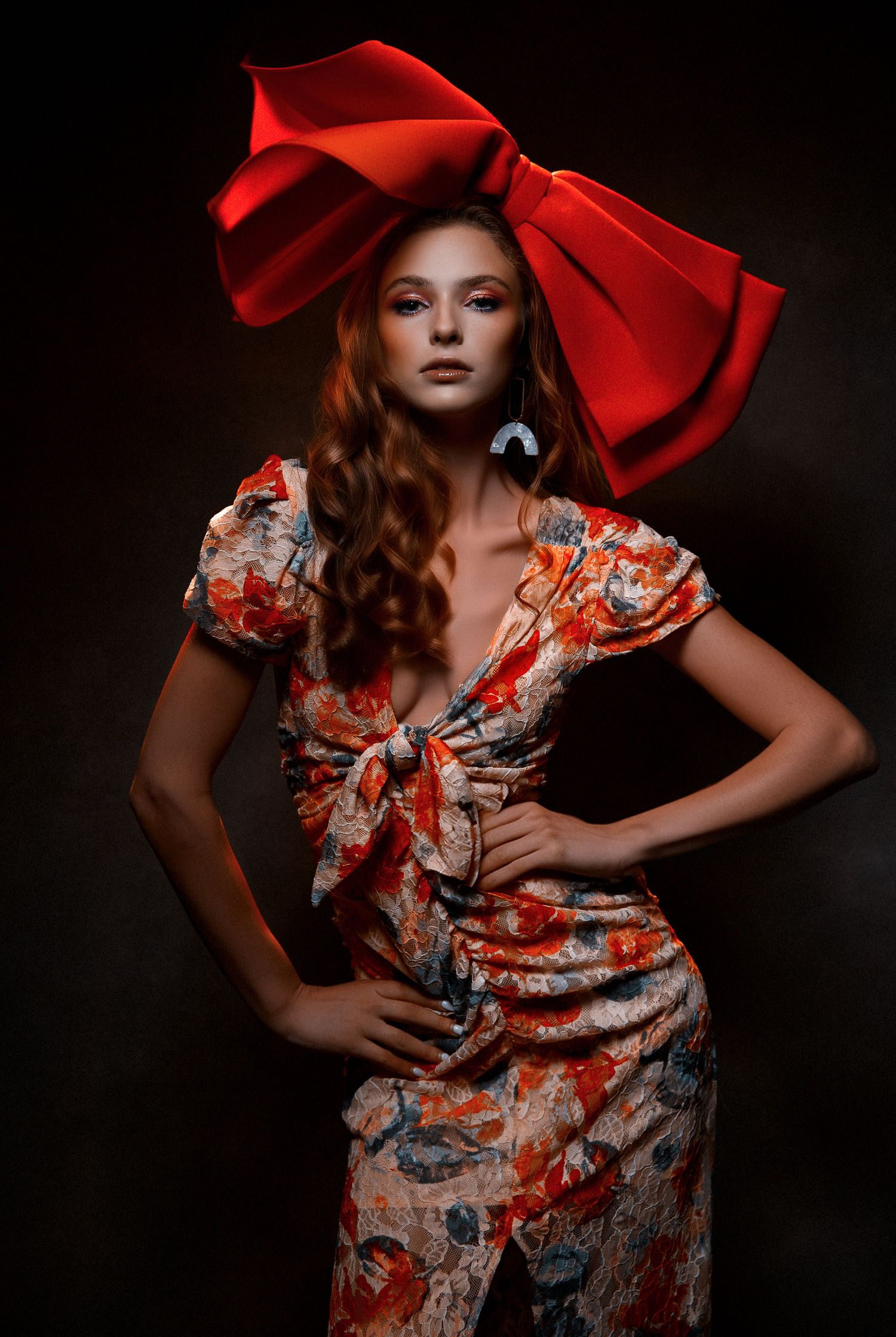 Moody fashion portraits featuring a floral dress and oversized red bow against dark background.