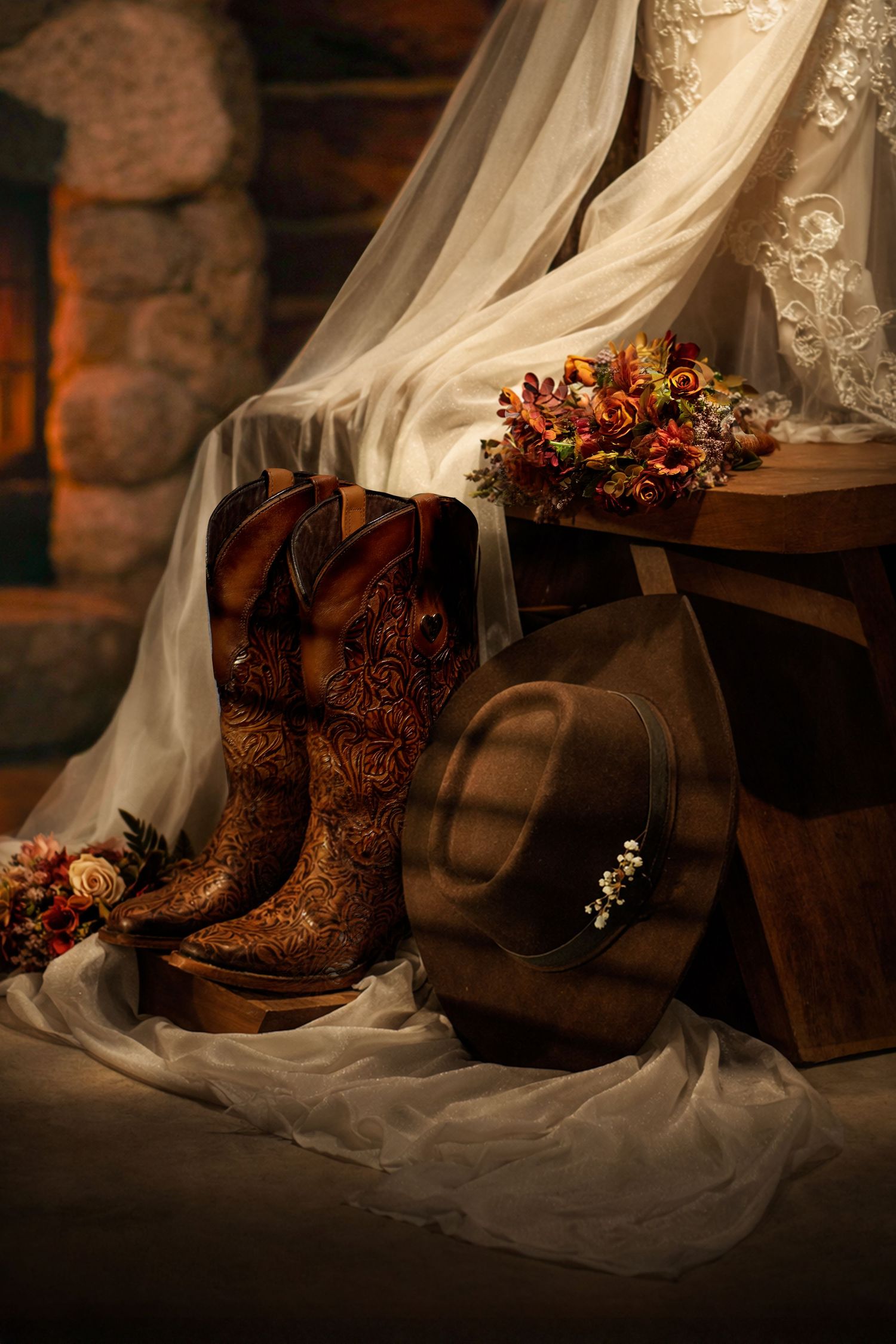 Wedding accessories including brown cowboy boots and lace dress details in warm cabin lighting.