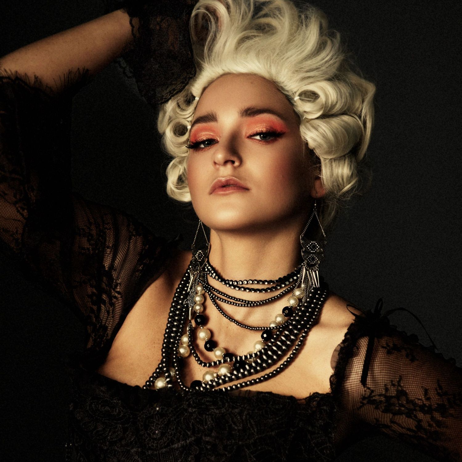 Dramatic portrait series featuring vintage-style hair and layered pearl necklaces in dark lighting.
