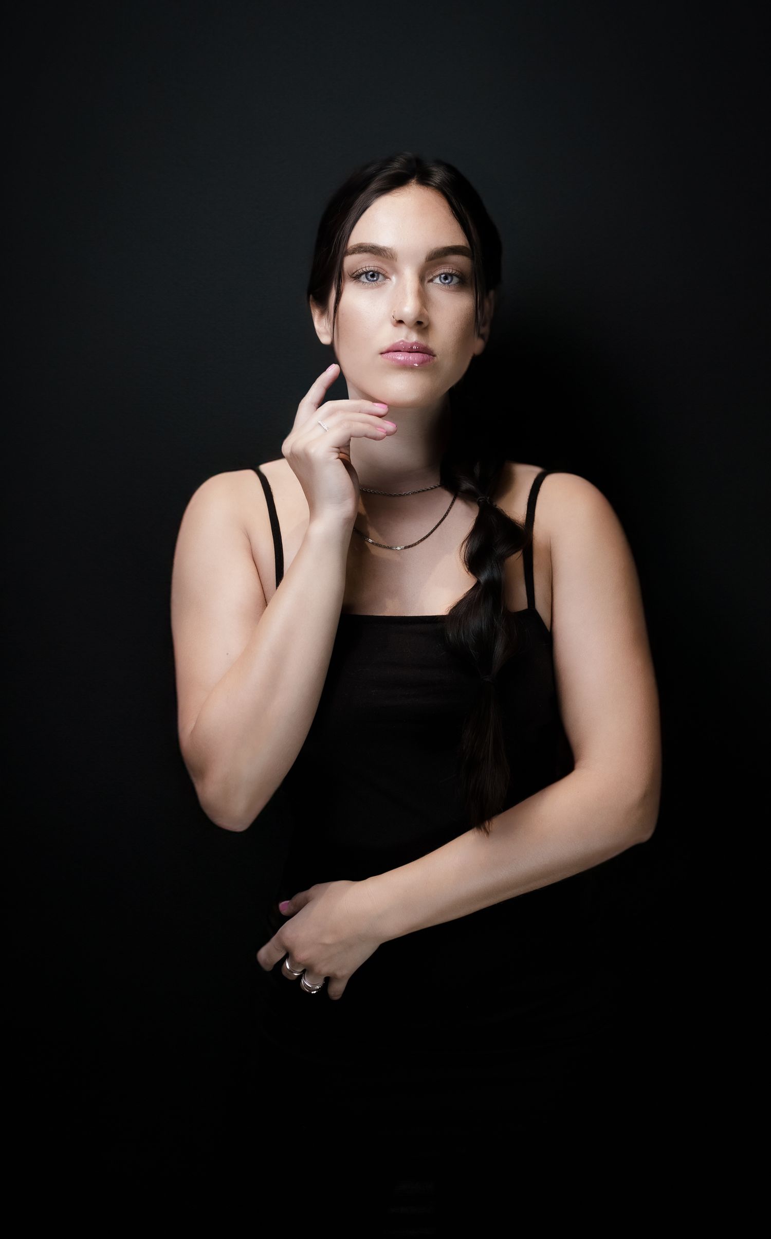 Moody portrait series against black background featuring dramatic shadows and poses.