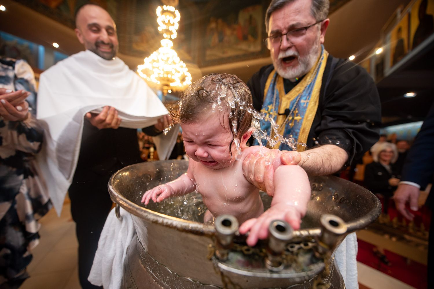 Greek Orthodox baptism ceremony in Toronto with baby receiving the sacrament during a traditional church baptism.