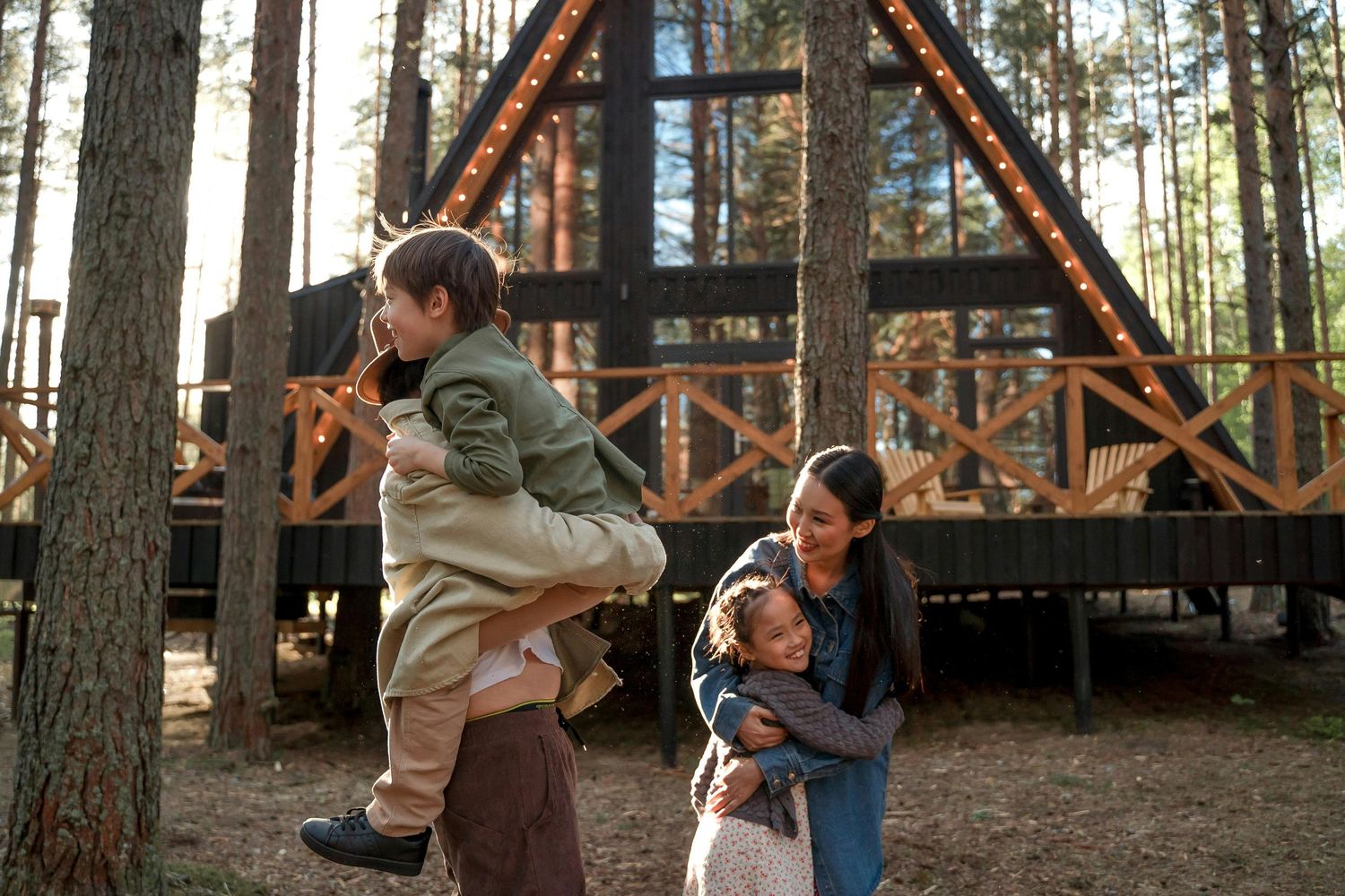 Two people walk through a forest while holding hands beneath tall wooden beams and pine trees.