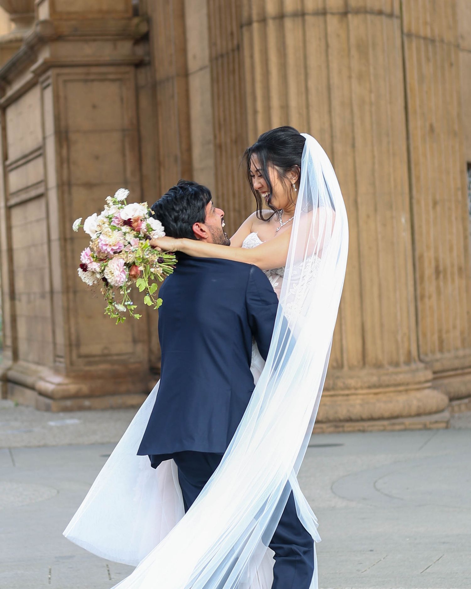 Bride and groom sharing a kiss with flowing veil | Nuvue Visuals wedding photography at Palace of Fine Arts San Francisco