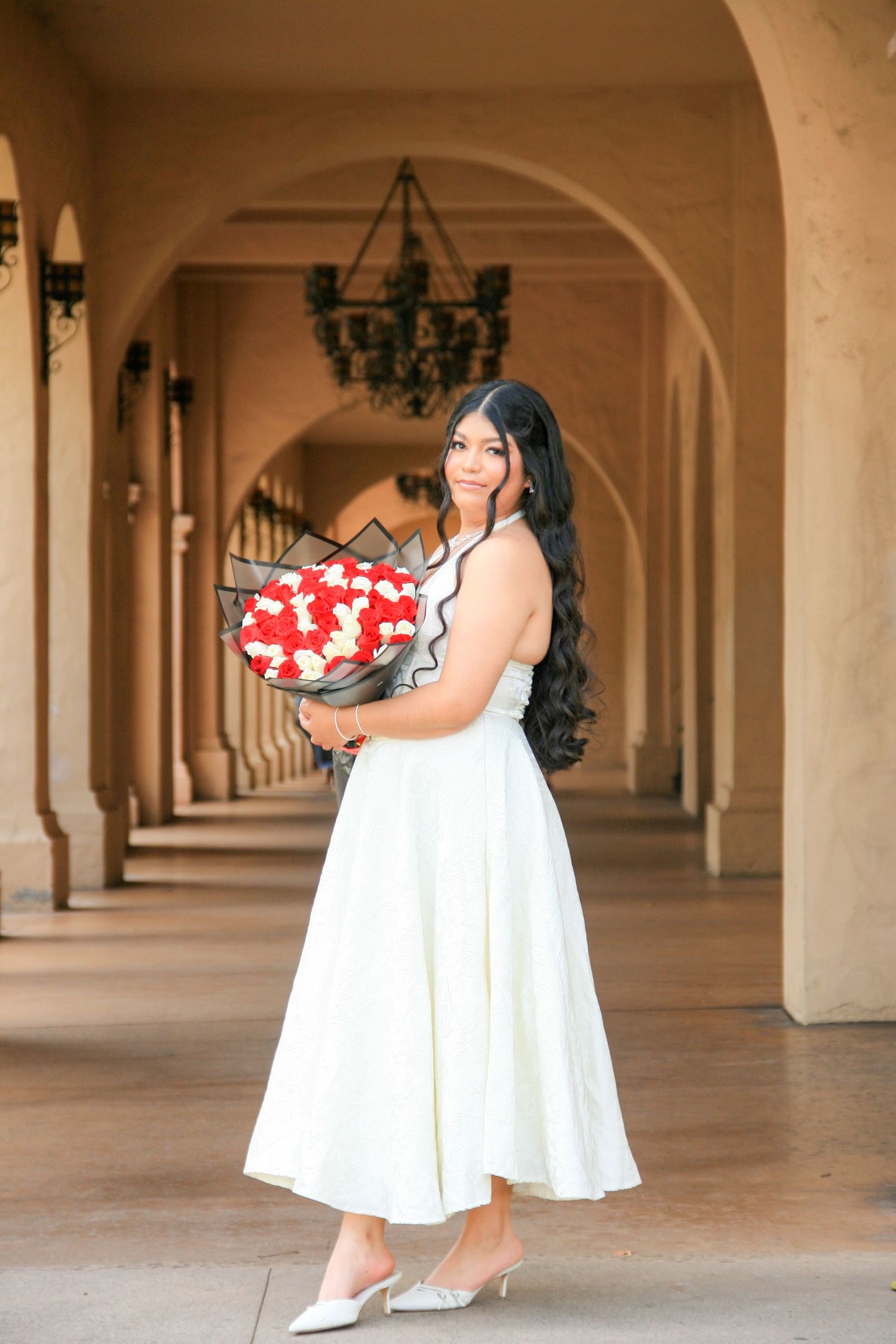 Woman in white dress holding a holiday wreath at Balboa Park | Nuvue Visuals holiday photo session in San Diego
