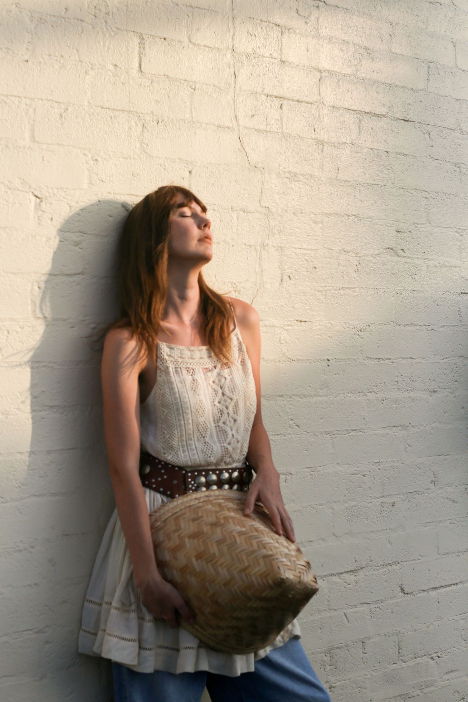 Woman posing in natural light against white brick wall | Nuvue Visuals lifestyle portraits in San Diego