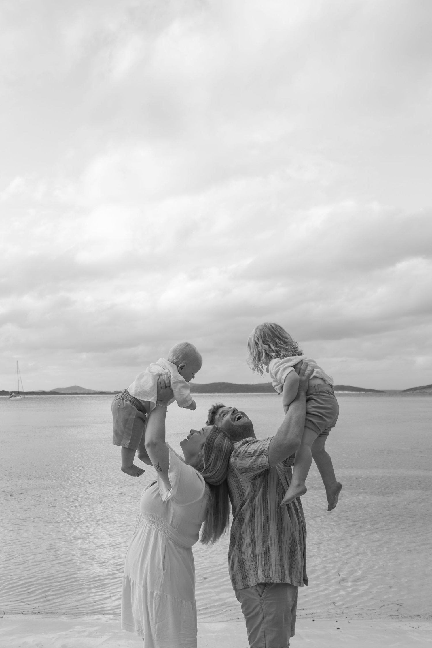 Parents throwing kids up in the air making them laugh at a candid family photography session in Albany.