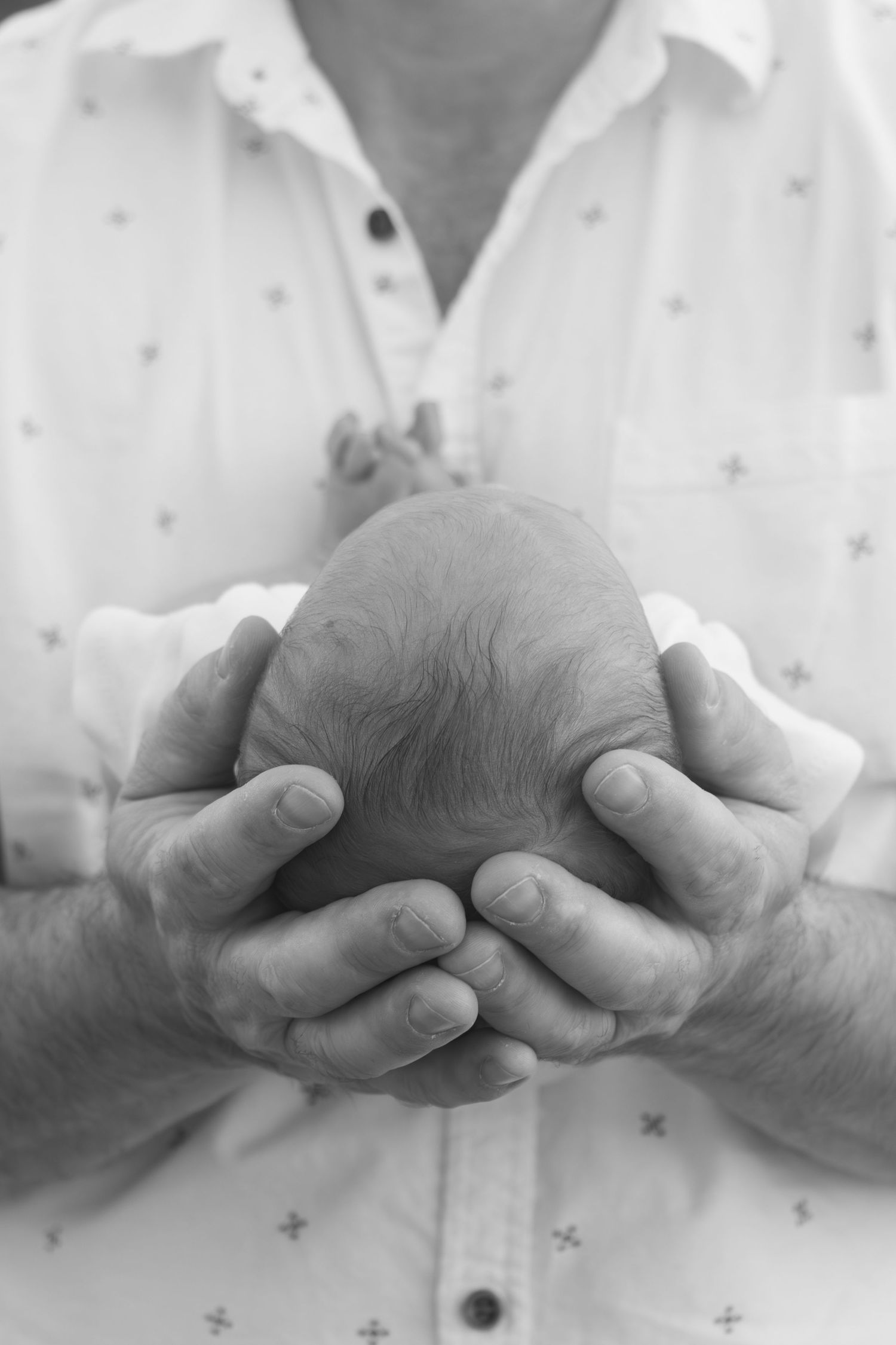 Parents cuddling their newborn baby outdoors during a relaxed lifestyle newborn photography session in Perth.
