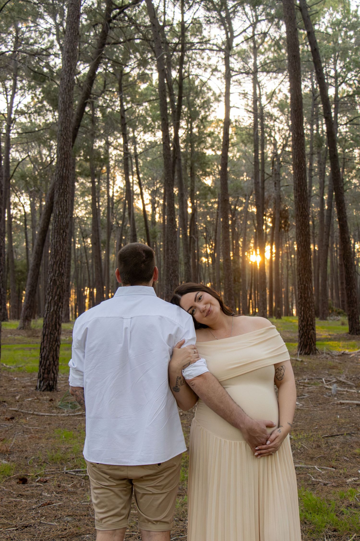 Couple celebrating their pregnancy announcement with natural, candid photos at Gnangara Pines in Perth during golden hour