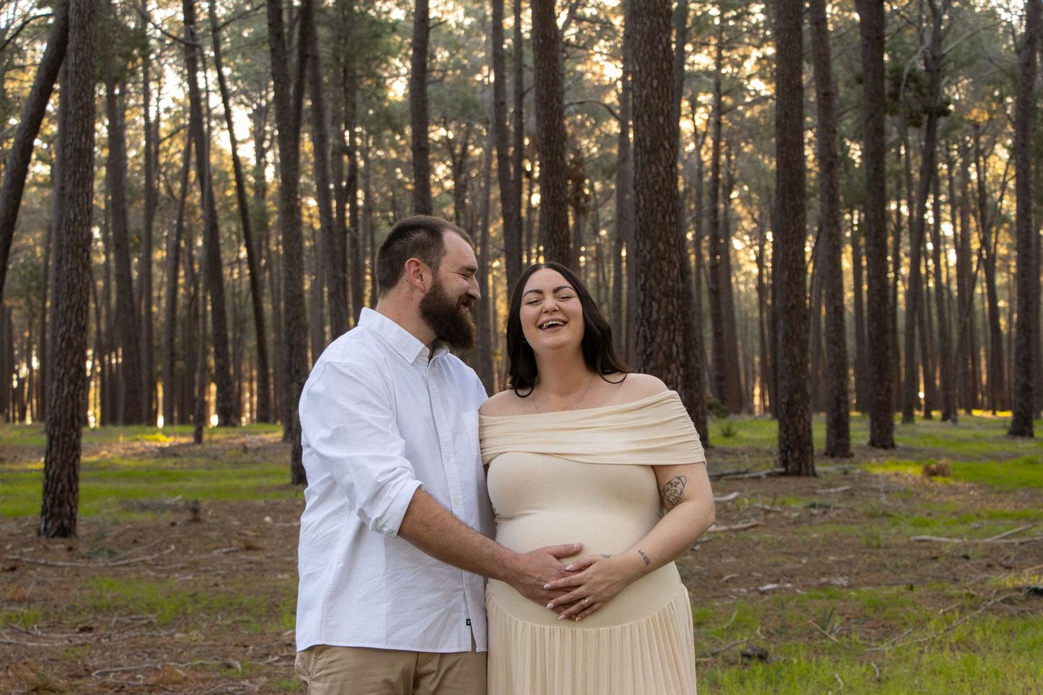 Couple celebrating their pregnancy announcement with natural, candid photos at Gnangara Pines in Perth during golden hour