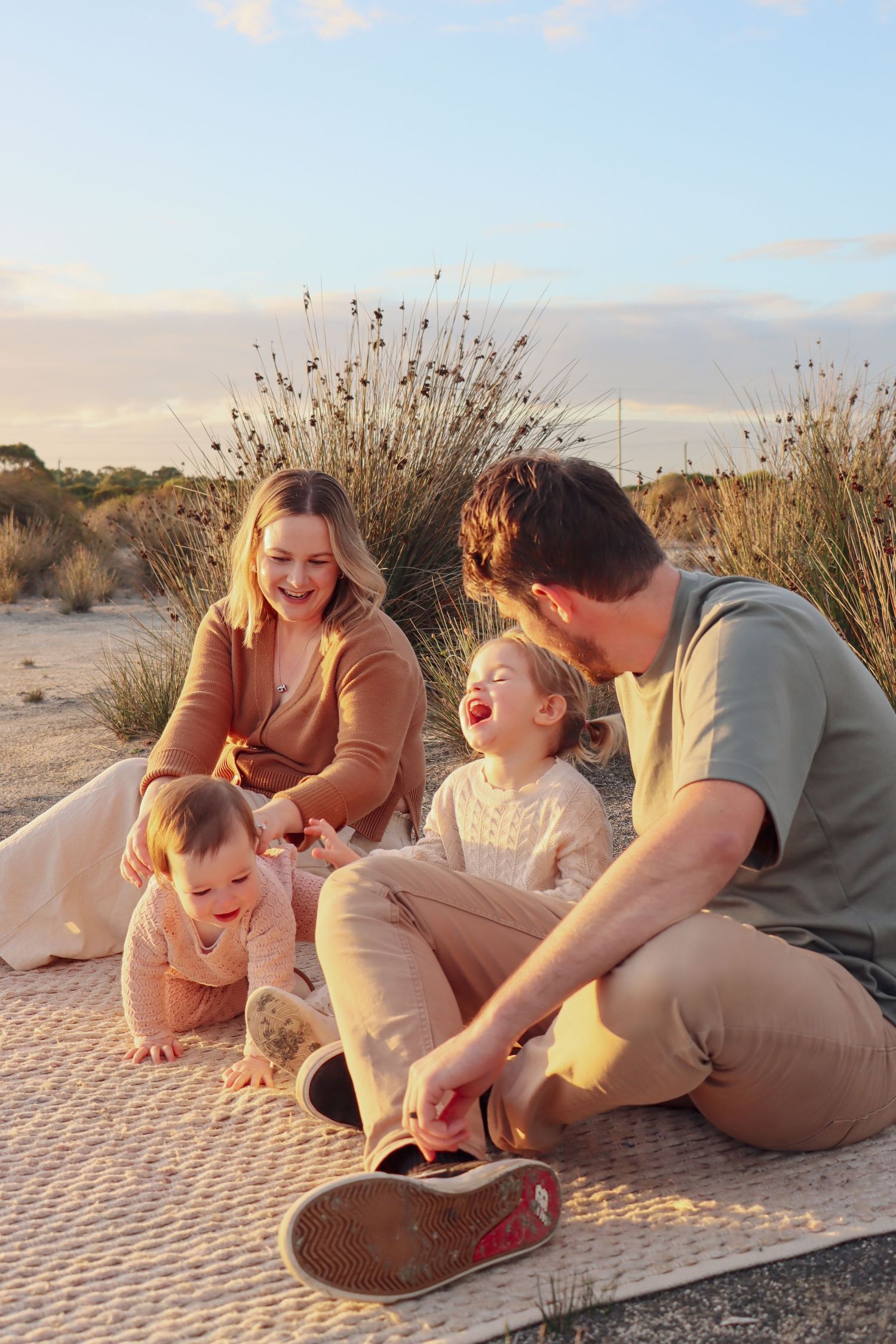 Mum, dad and their daughters at salt flats at sunset during a candid family photography session.