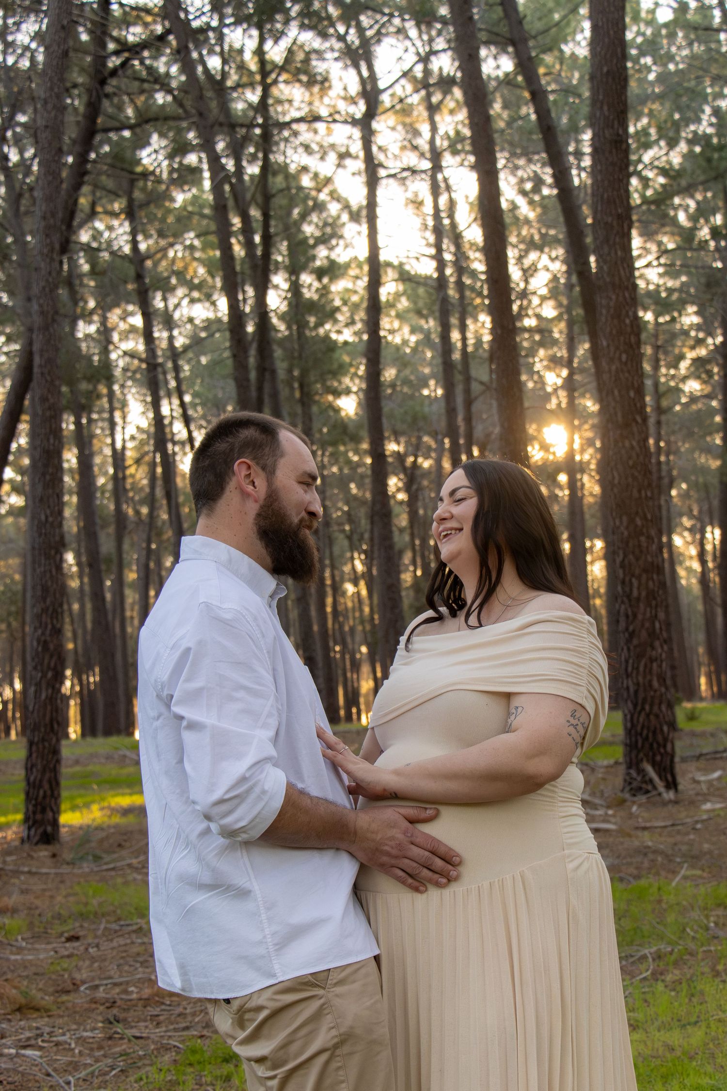 Couple celebrating their pregnancy announcement with natural, candid photos at Gnangara Pines in Perth during golden hour