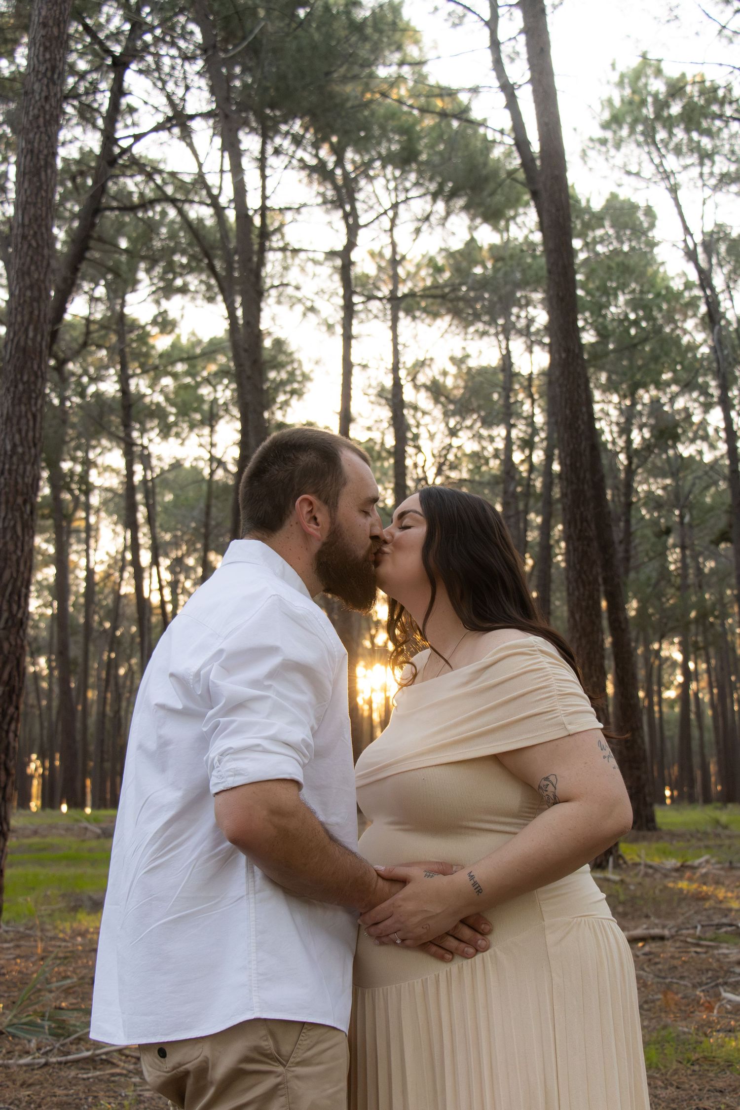 Couple celebrating their pregnancy announcement with natural, candid photos at Gnangara Pines in Perth during golden hour