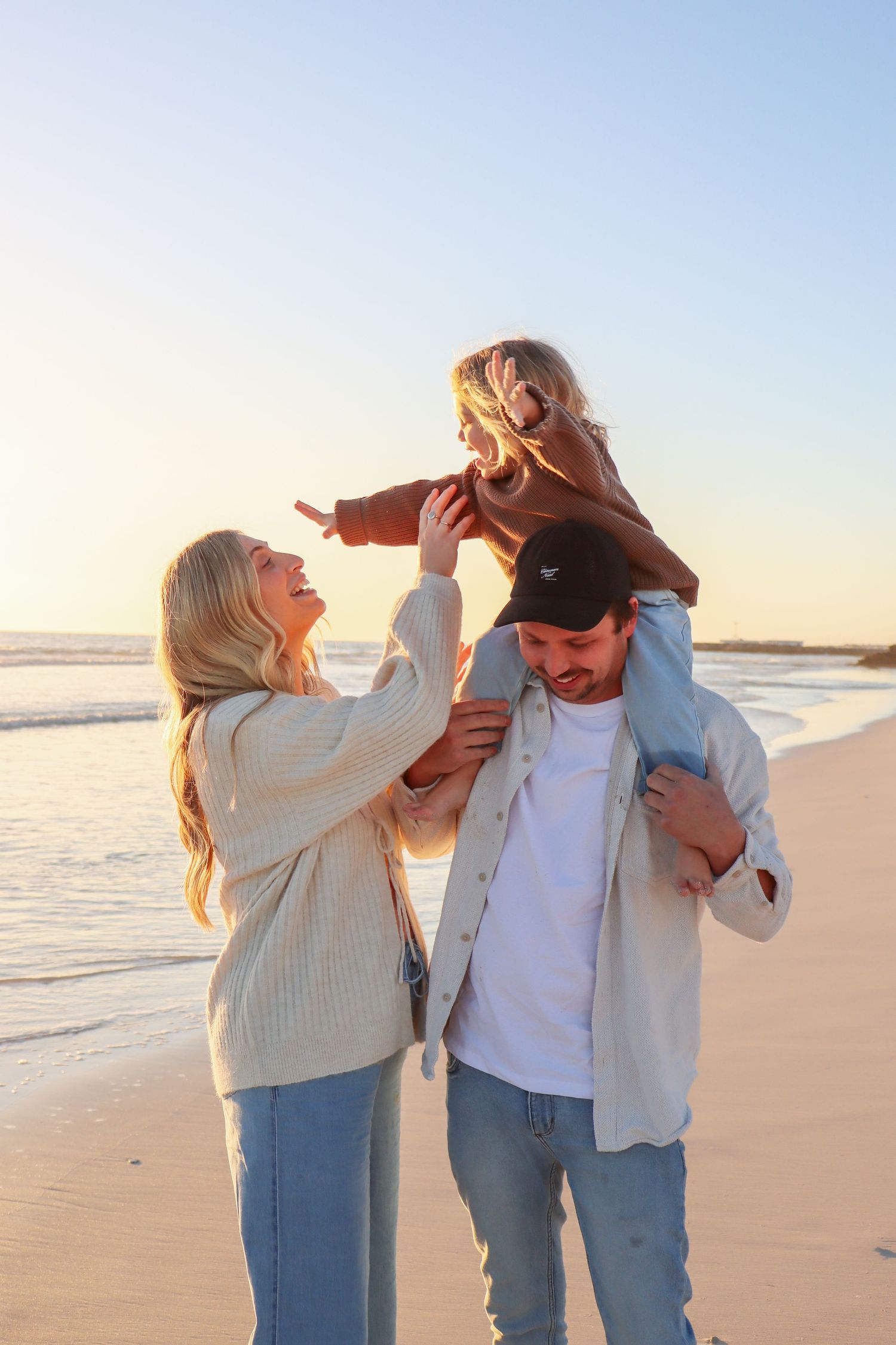 Young family running, cuddling and laughing together during a fun outdoor family photography session in Perth.