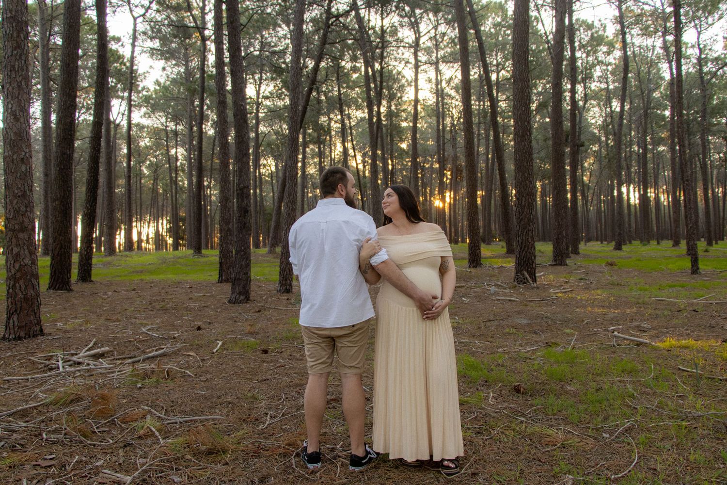 Couple celebrating their pregnancy announcement with natural, candid photos at Gnangara Pines in Perth during golden hour