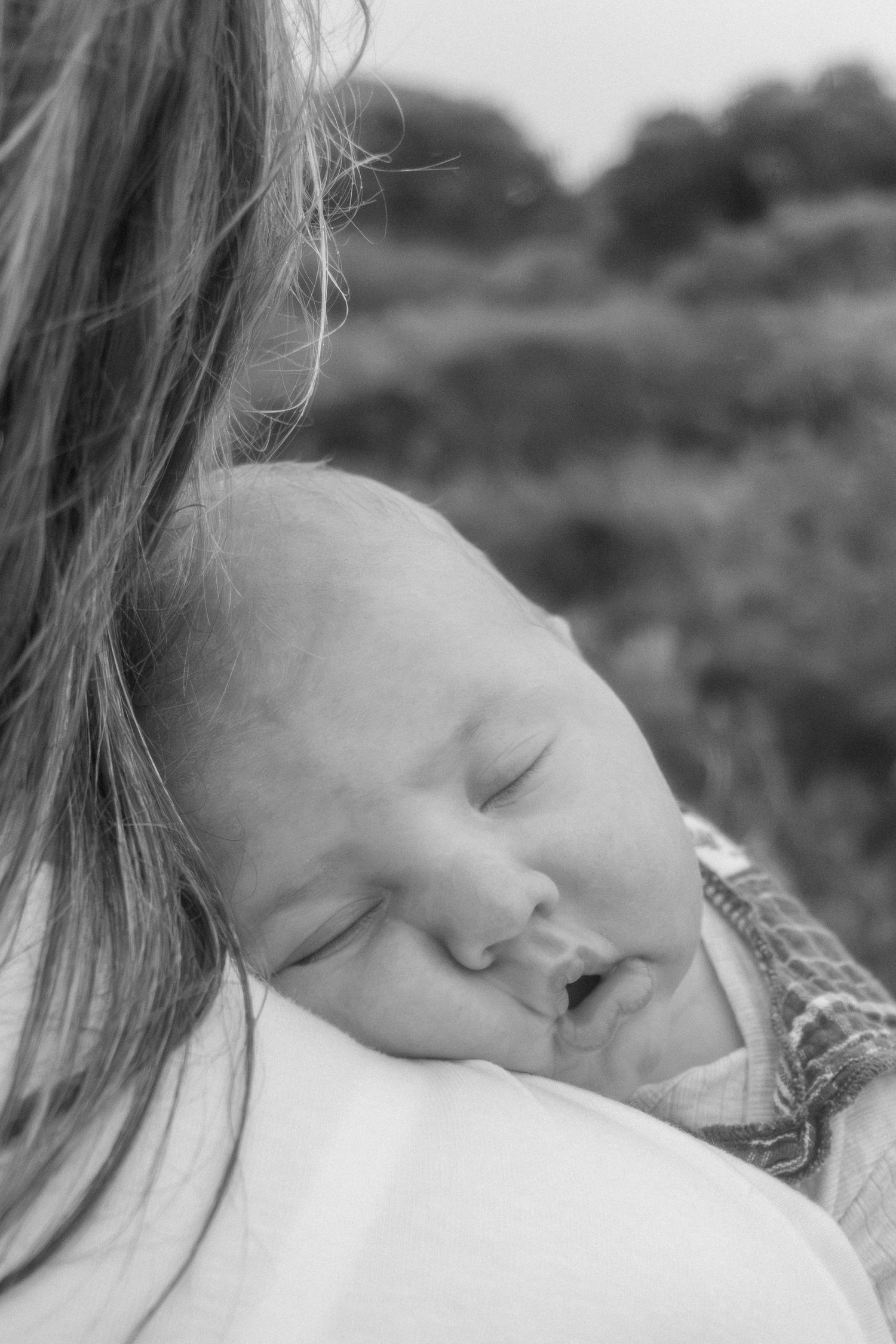 Mum cuddling her newborn baby outdoors during a relaxed lifestyle newborn photography session in Albany.