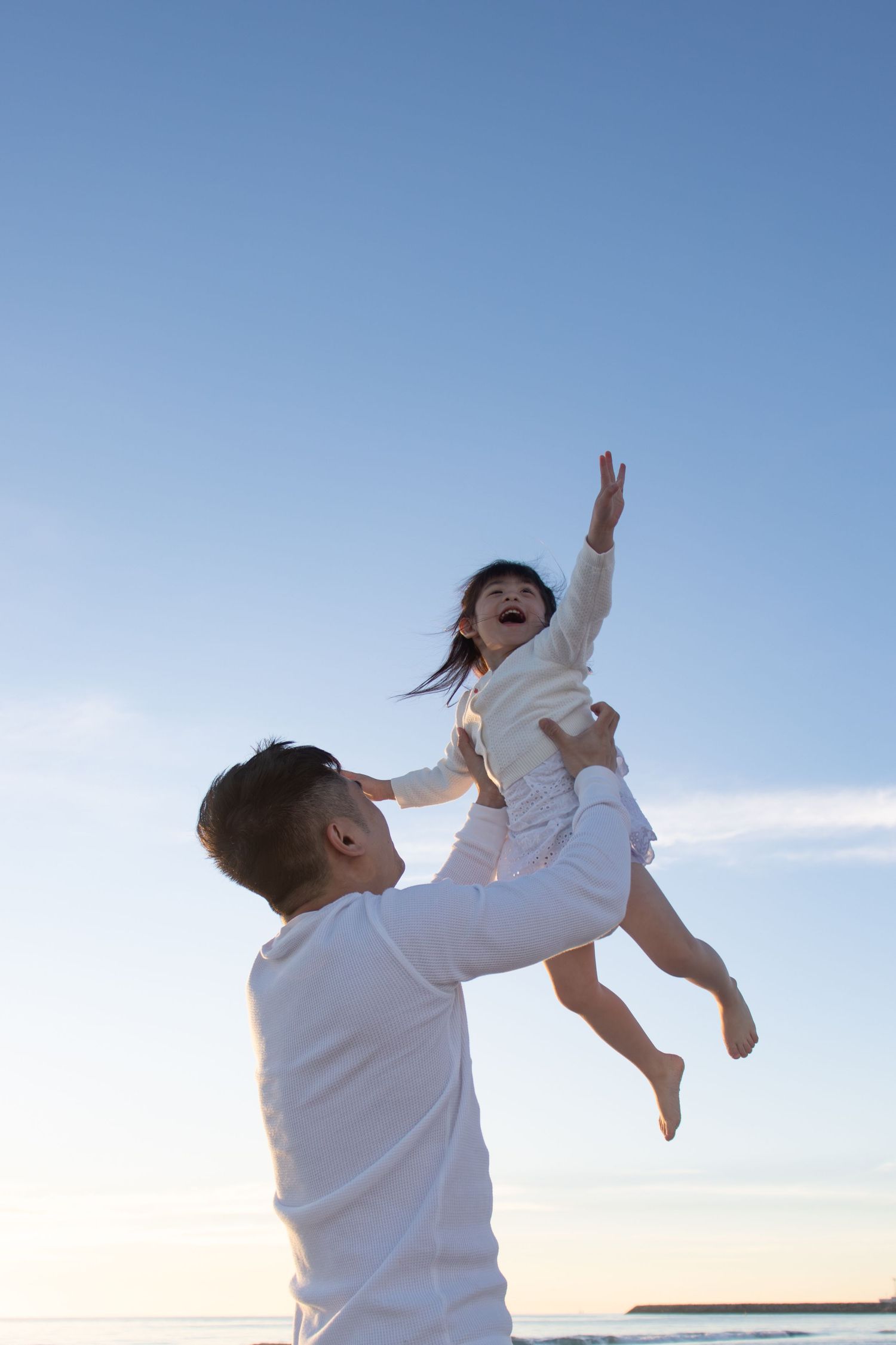 Dad carrying his daughter on his shoulders during a playful family photoshoot at Mullaloo Beach.